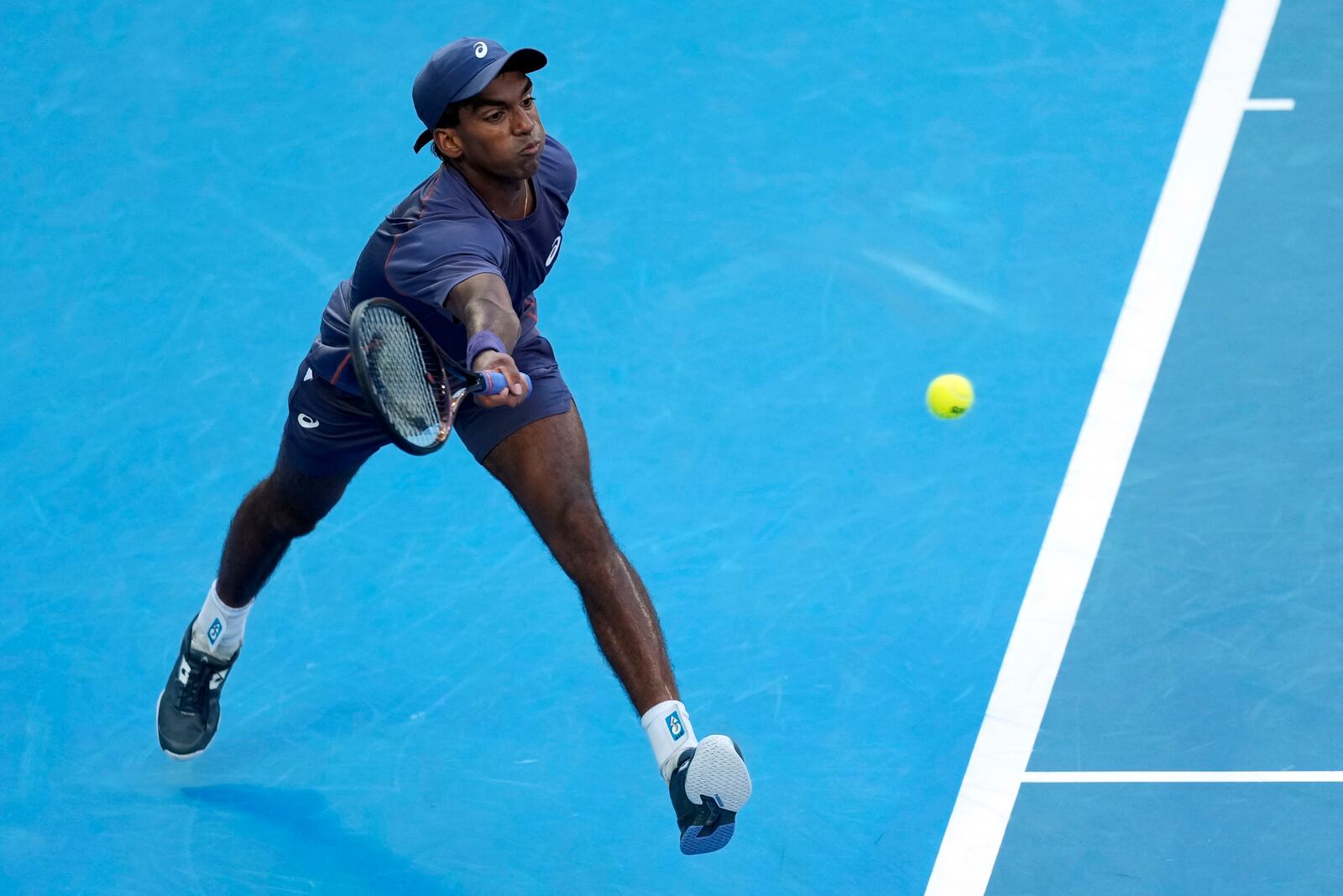 Nishesh Basavareddy of the U.S. plays a forehand return to Novak Djokovic of Serbia during their first round match at the Australian Open tennis championship in Melbourne, Australia, Monday, Jan. 13, 2025. (AP Photo/Asanka Brendon Ratnayake)