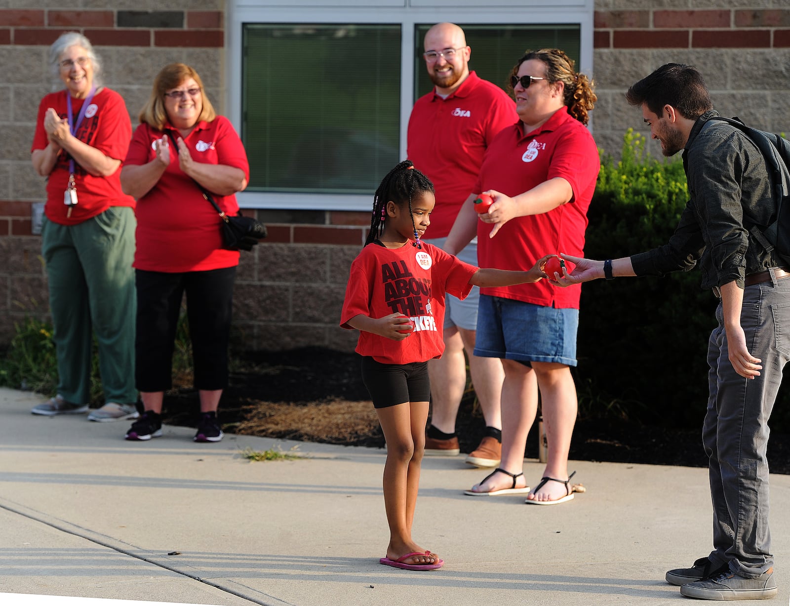 Kaliyah Williams, age 6, helps the Dayton teachers union members clap in first year teachers Thursday, Aug. 3, 2023 at Thurgood Marshall High School. MARSHALL GORBY\STAFF