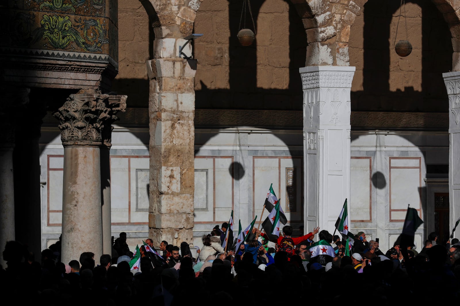 Syrians attend Friday prayers outside the 7th century Umayyad Mosque in Damascus, Syria, Friday, Dec. 13, 2024. (AP Photo/Omar Sanadiki)