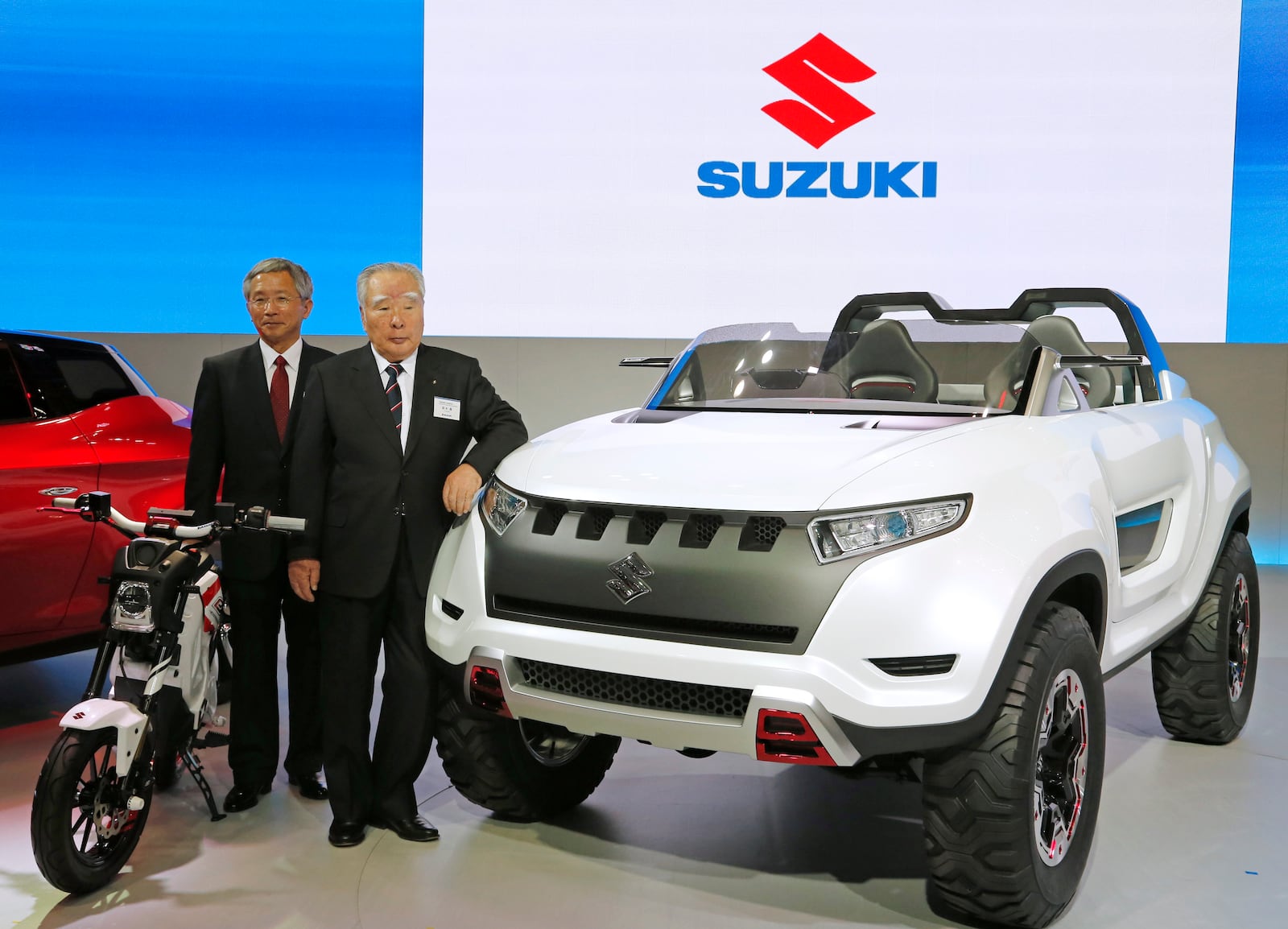 FILE - Suzuki Motor Corp. President and Chairman Osama Suzuki, right, and Vice President Osamu Honda pose with a Suzuki X-Lander hybrid concept car on display at a media preview for the Tokyo Motor Show in Tokyo, Nov. 20, 2013. (AP Photo/Shuji Kajiyama, File)