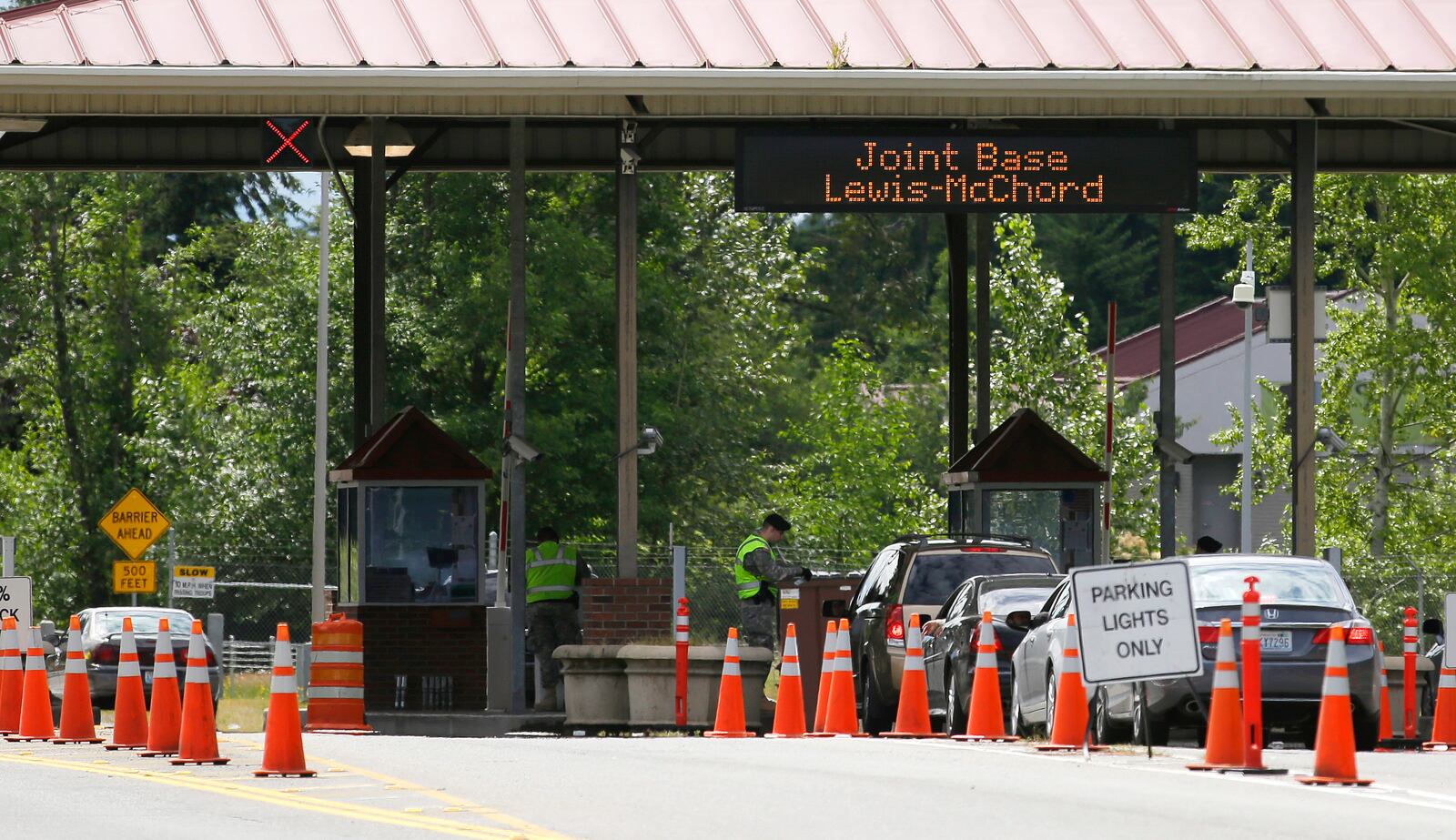 FILE - Cars enter Joint Base Lewis-McChord, Wash., at the Madigan Gate, Tuesday, June 25, 2013. (AP Photo/Ted S. Warren, File)