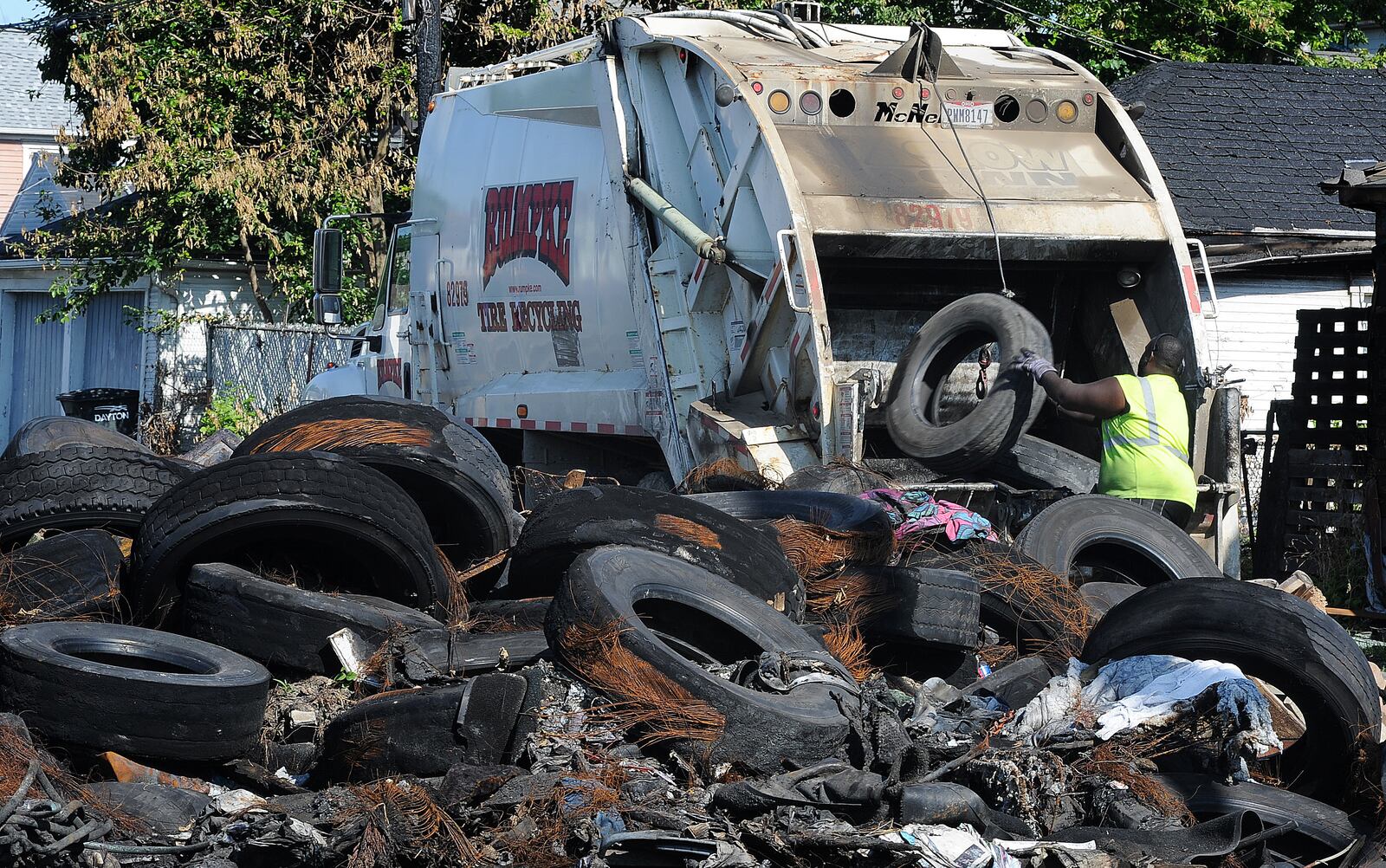 A Rumpke employee loads old tires into a tire recycling truck Wednesday, June 12, 2024 in the 1400 block of Leonhard Street. The EPA ordered the cleanup after the tires caught fire at the beginning of the month. MARSHALL GORBY\STAFF