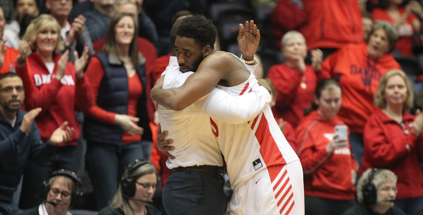 Dayton’s Josh Cunningham hugs Anthony Grant after leaving the court in his final home game against La Salle on Wednesday, March 6, 2019, at UD Arena. David Jablonski/Staff