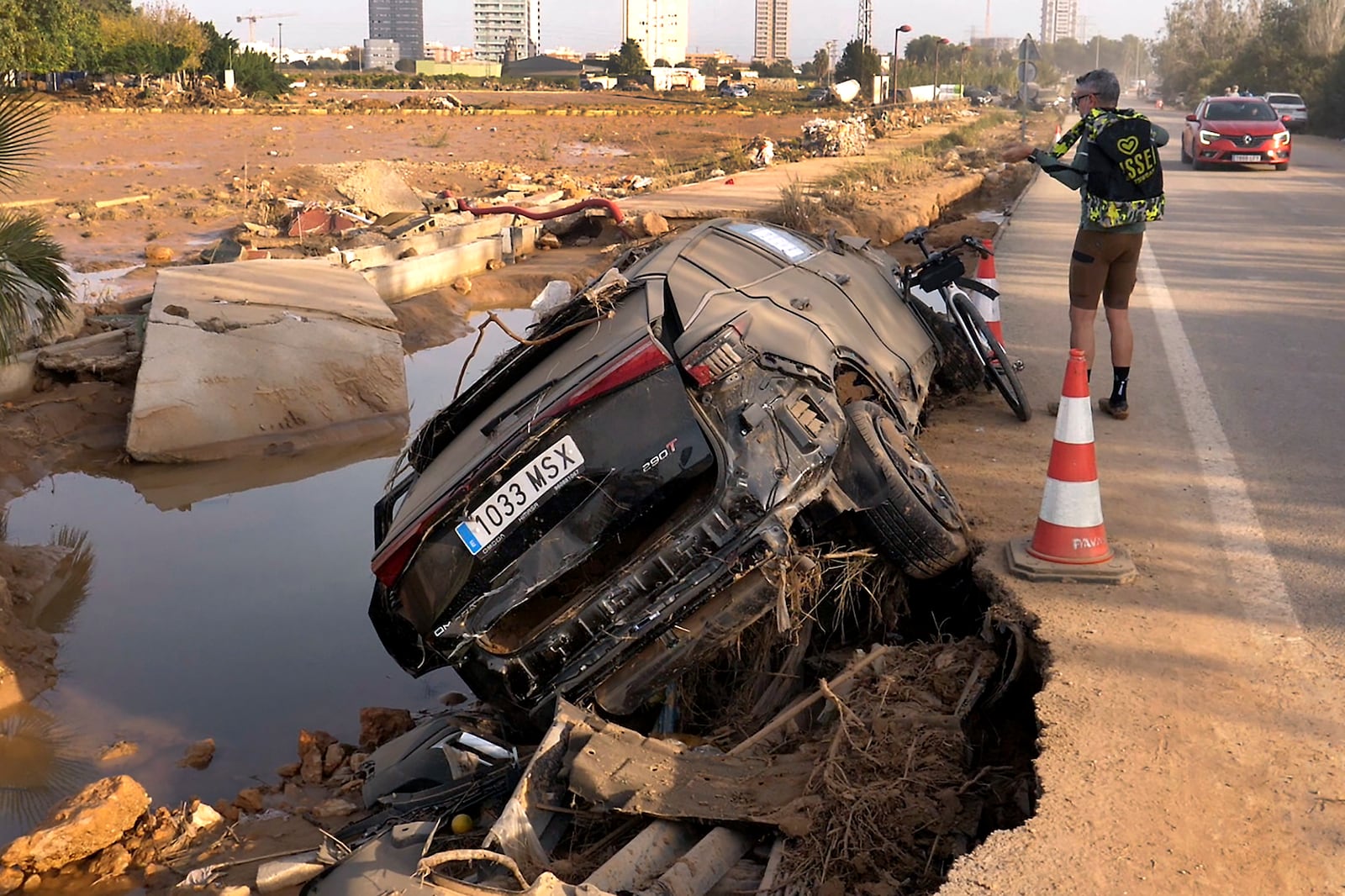 Jorge Tarazona stands next to a car in Paiporta, Valencia, Spain, Wednesday, Nov. 5, 2024, where his three-year-old niece and sister-in-law died in last week's floods in eastern Spain. (AP Photo/Paolo Santalucia)