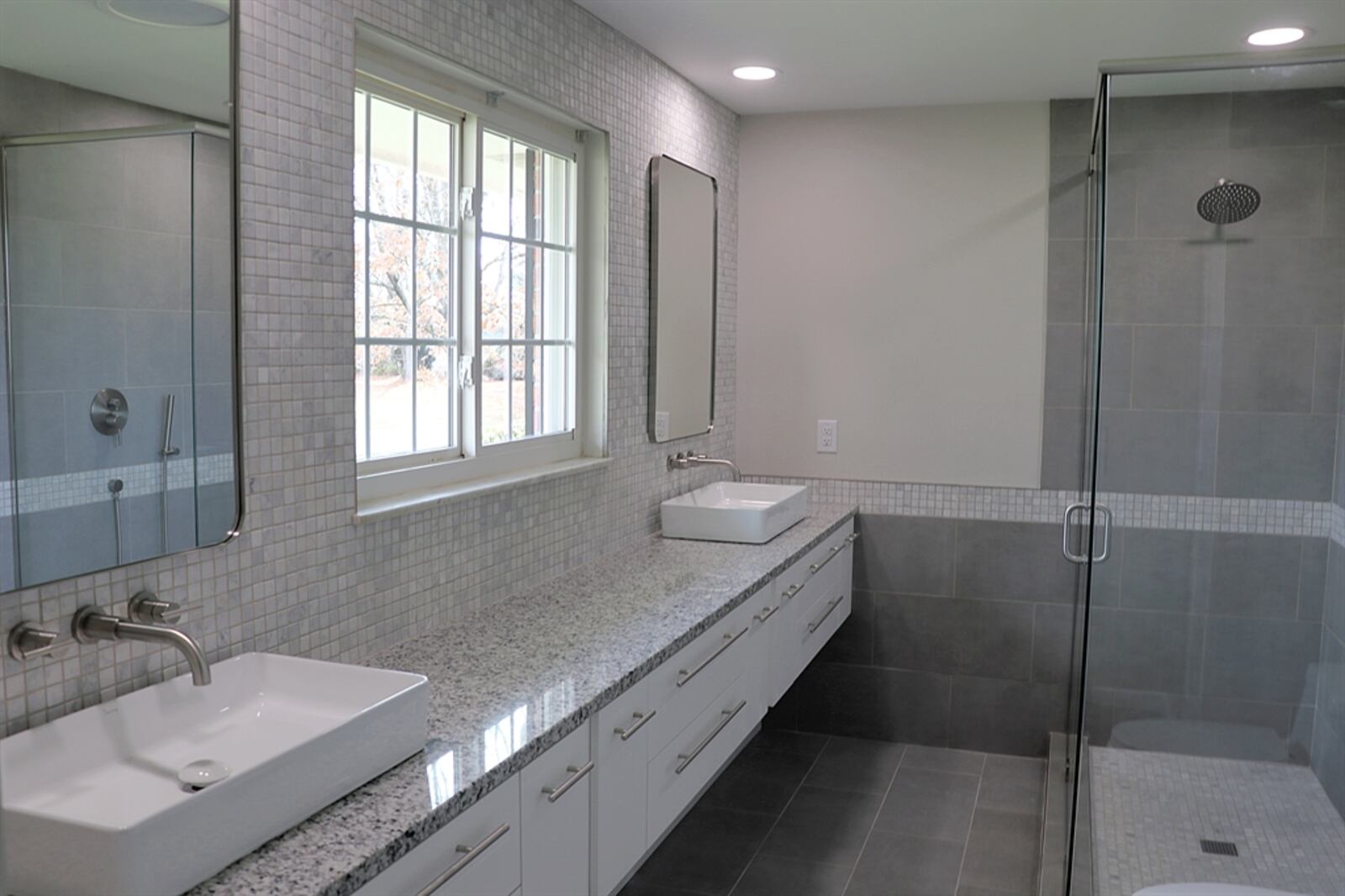 The redesigned primary bathroom includes a 12-foot, wall-mounted vanity with granite counter and walk-in shower with ceramic-tile surround. Contributed by Kathy Tyler 