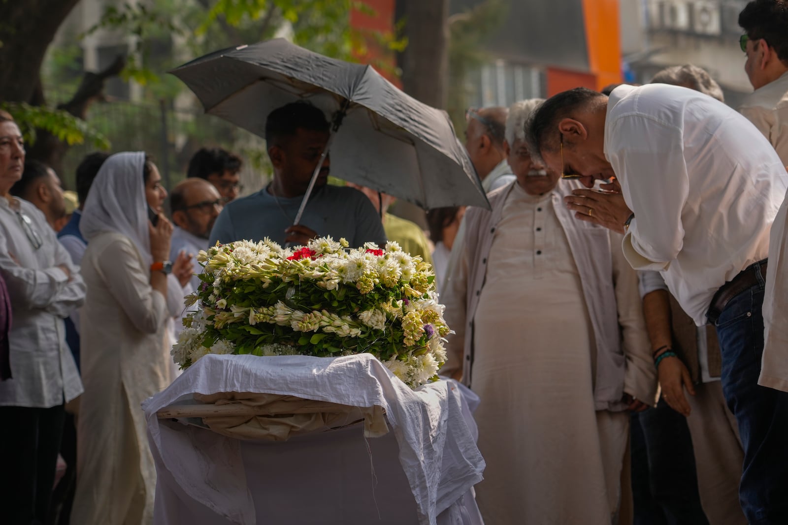 Bollywood actor Boman Irani, right, pays homage to Shyam Benegal, a renowned Indian filmmaker who passed away on Monday, during Benegal's funeral in Mumbai, India, Tuesday, Dec. 24, 2024. (AP Photo/Rafiq Maqbool)