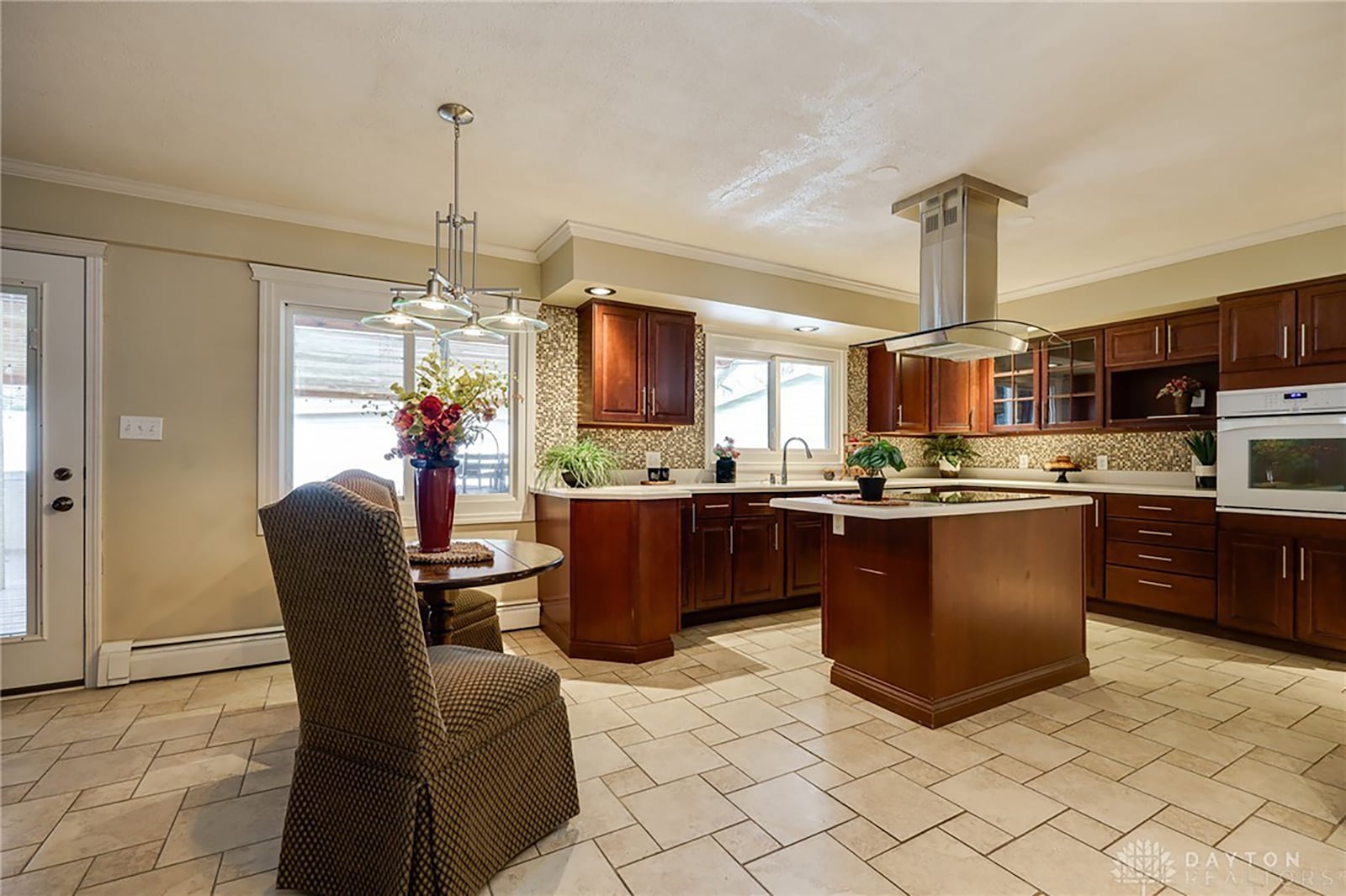 The remodeled kitchen has tile flooring, an island with breakfast bar, a dining area and walk in pantry.