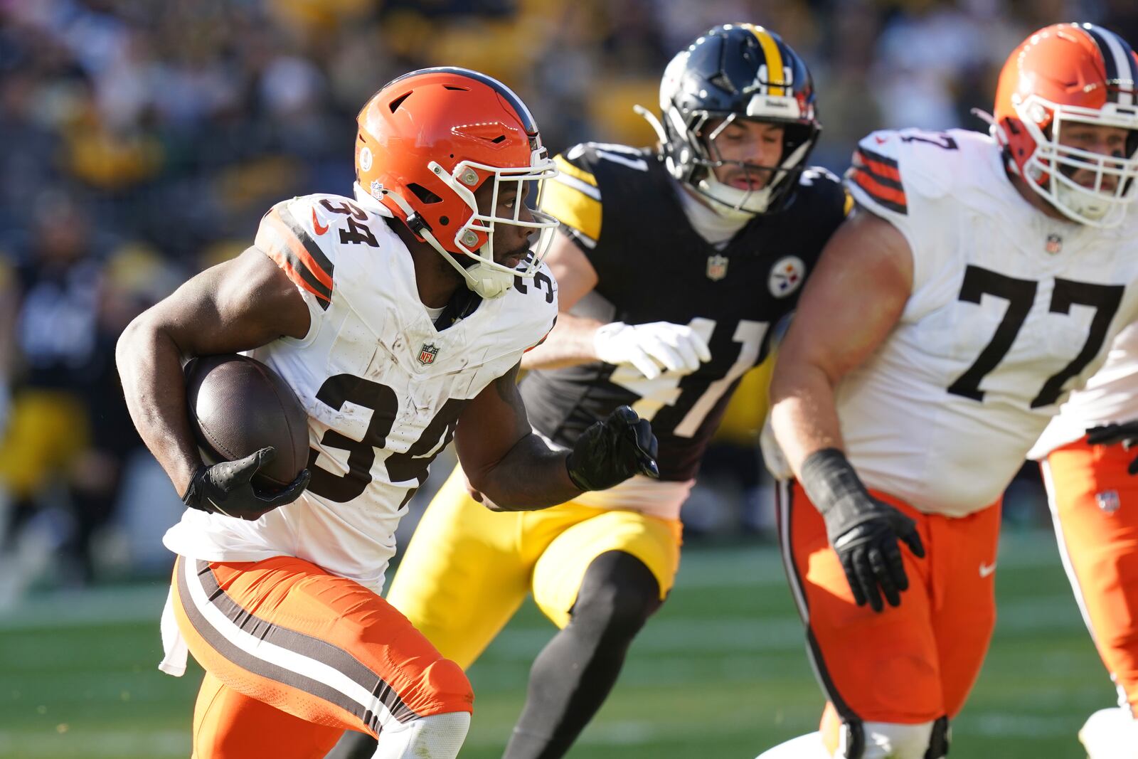 Cleveland Browns running back Jerome Ford (34) carries past Pittsburgh Steelers linebacker Payton Wilson (41) and teammate Wyatt Teller (77) in the first half of an NFL football game in Pittsburgh, Sunday, Dec. 8, 2024. (AP Photo/Matt Freed)