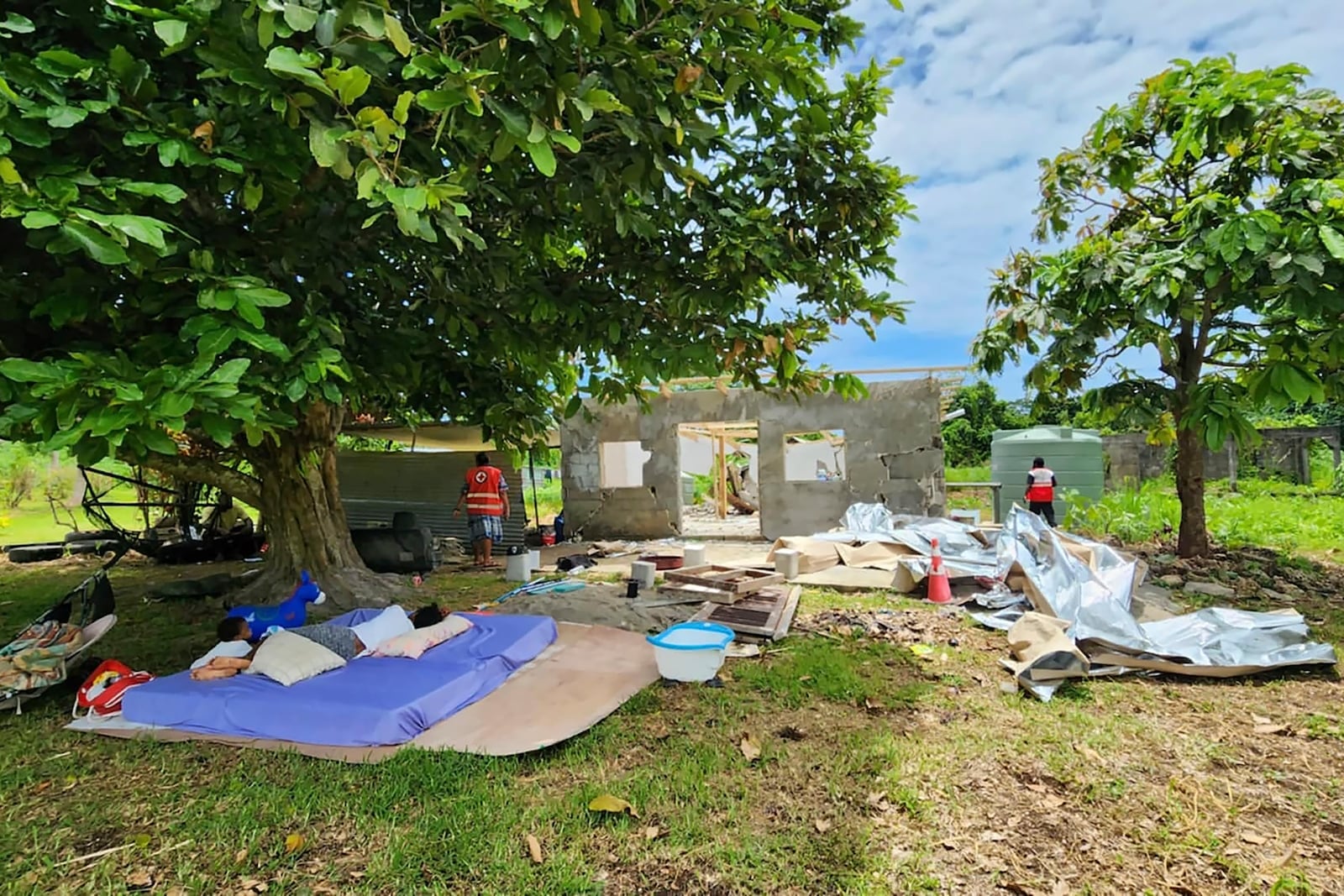 In this photo released by Vanuatu Red Cross Society, bedding lies outside a damaged house in Efate, Vanuatu, Thursday, Dec. 19, 2024, following a powerful earthquake that struck just off the coast of Vanuatu in the South Pacific Ocean. (Vanuatu Red Cross Society via AP)