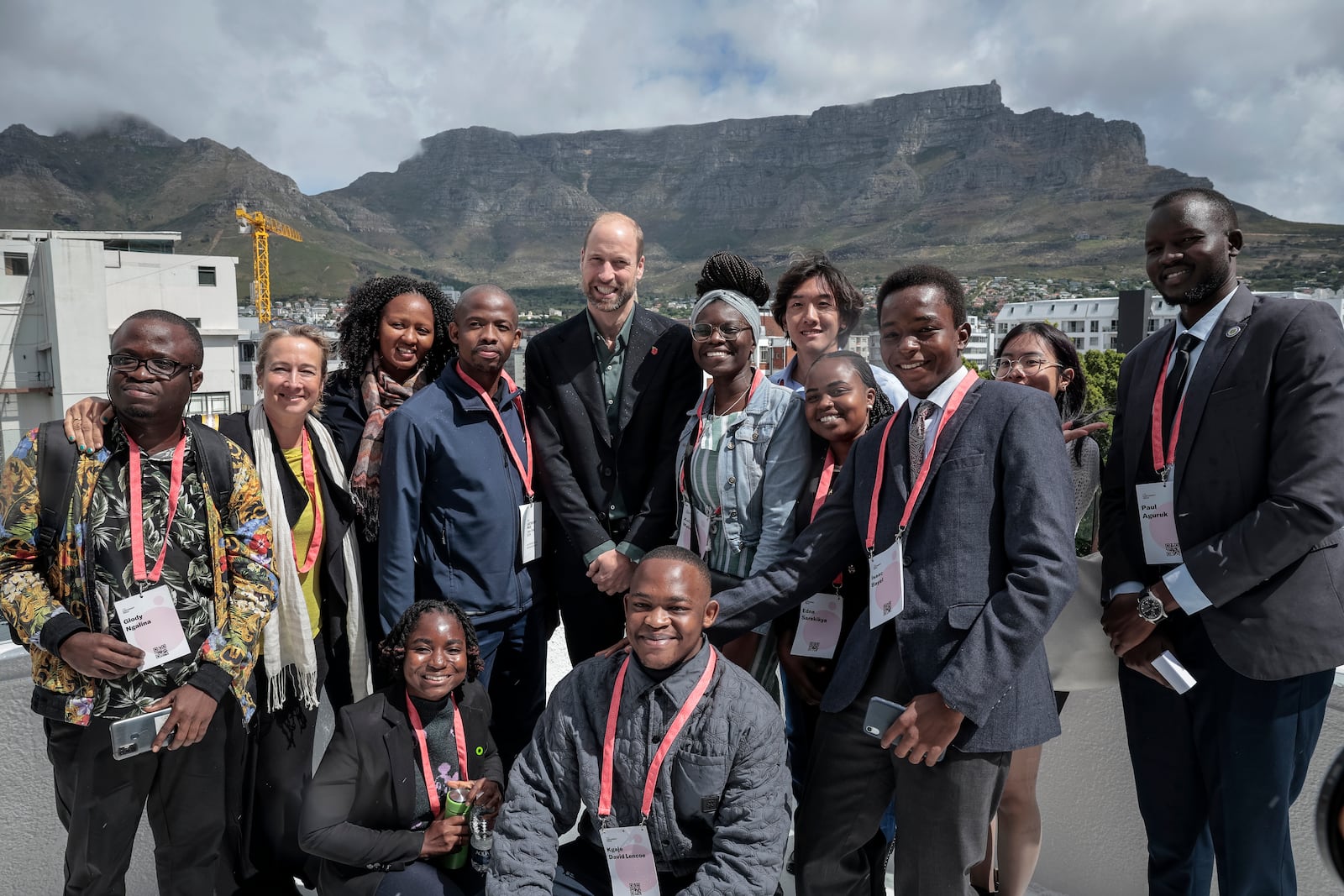 Britain's Prince William, center, poses for a photo with a group of young people, with Table Mountain in the background, at the Earthshot Prize Climate Leaders Youth Programme at Rooftop on Bree in Cape Town, South Africa, Monday Nov. 4, 2024. (Gianluigi Guercia/Pool Photo via AP)