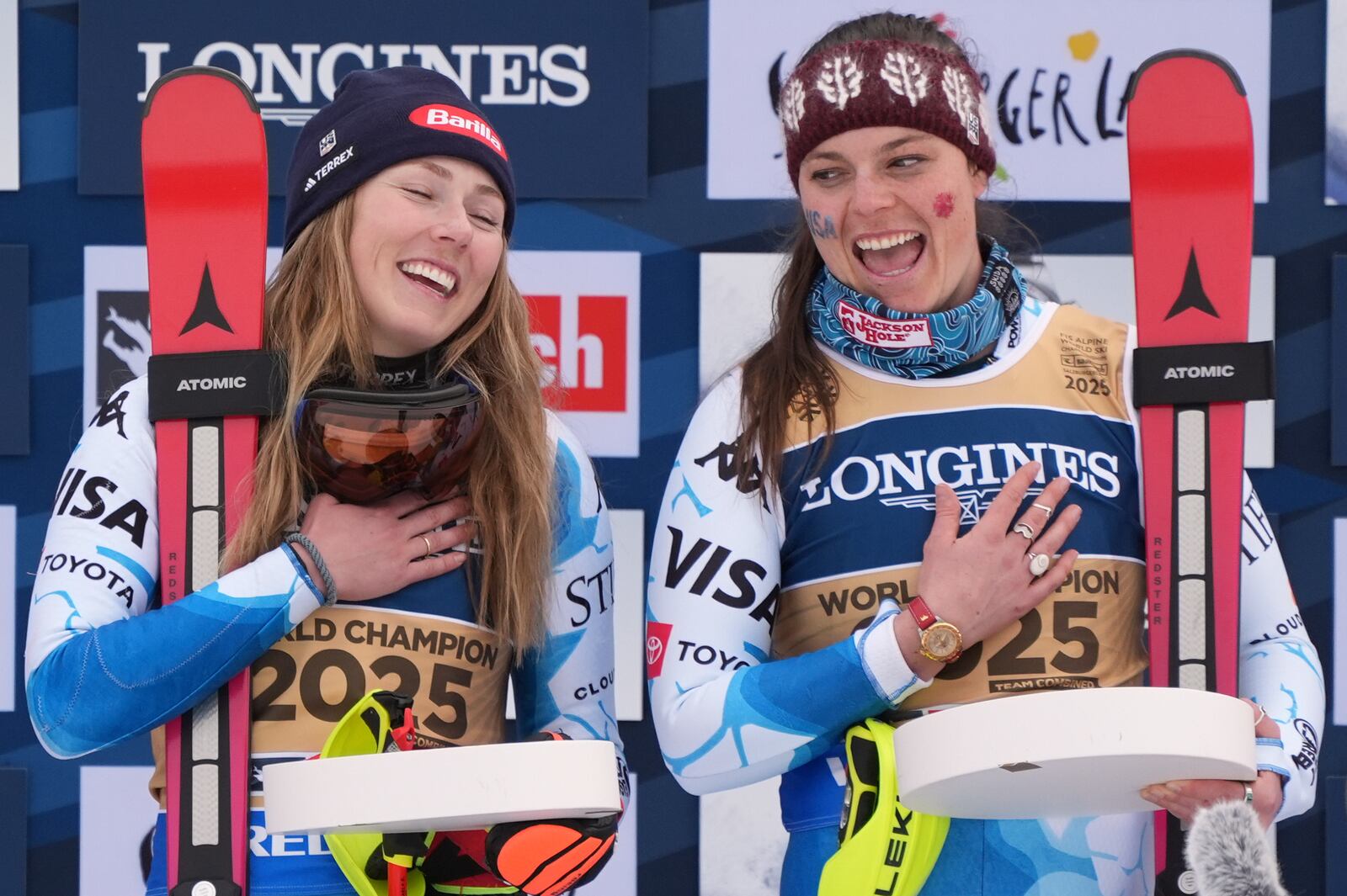 United States' Mikaela Shiffrin, left, and United States' Breezy Johnson, celebrate on the podium after winning the gold medal in a women's team combined event, at the Alpine Ski World Championships, in Saalbach-Hinterglemm, Austria, Tuesday, Feb. 11, 2025. (AP Photo/Giovanni Auletta)