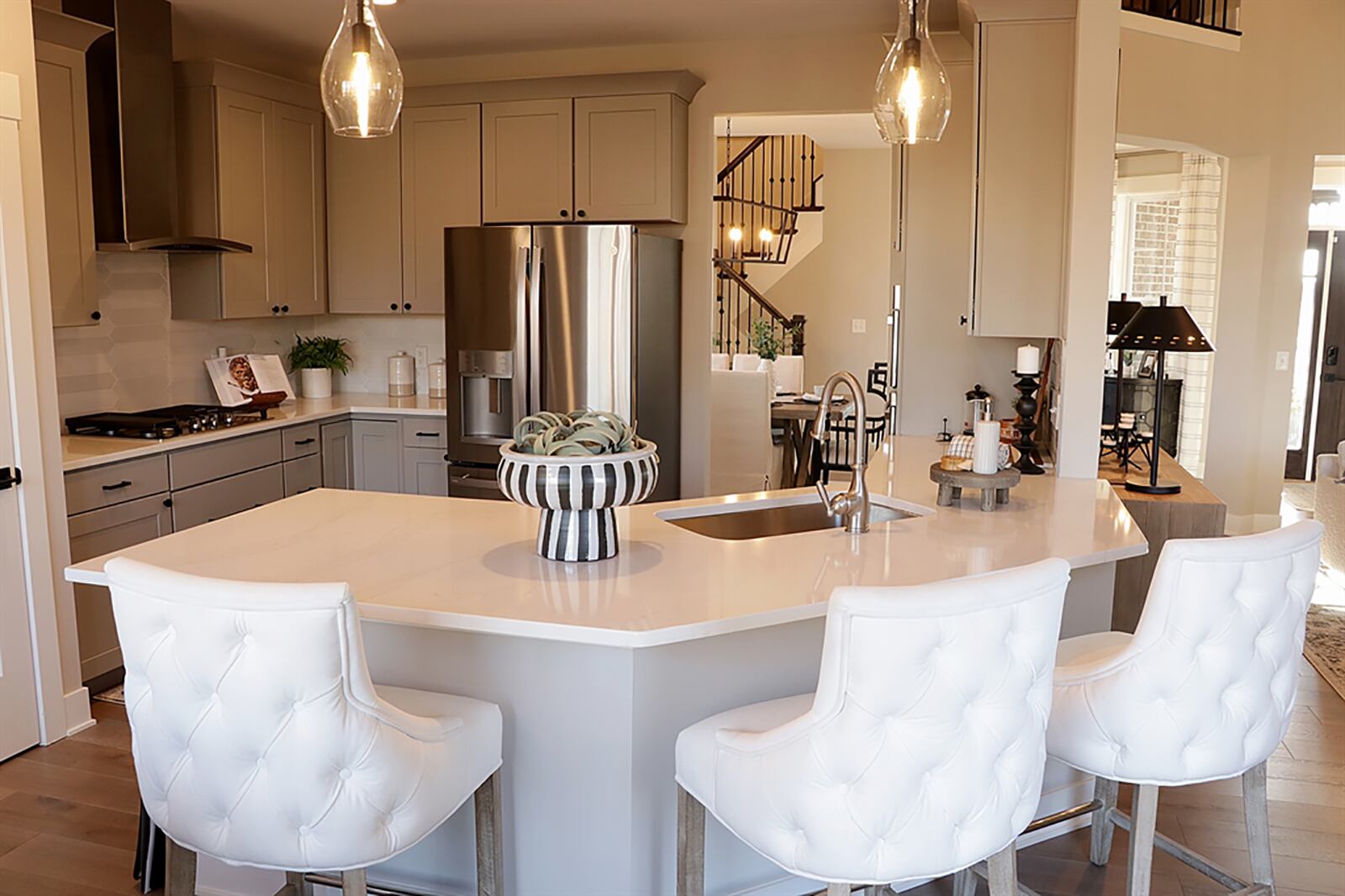 A peninsula counter divides the breakfast room from the kitchen. A single sink is built into the peninsula counter, and light gray cabinetry fills the kitchen. White countertops provide plenty of work space, and there is a pantry closet. CONTRIBUTED PHOTO BY KATHY TYLER