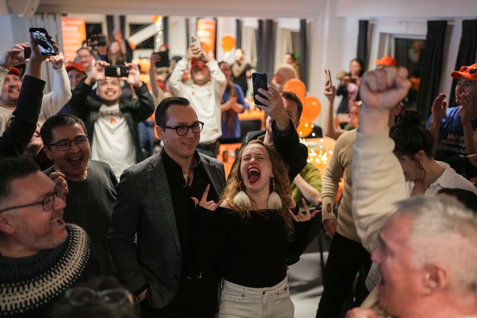 Candidate Aki-Matilda Høegh-Dam, of the Naleraq party, center, dances during a party after parliamentary elections in Nuuk, Greenland, Tuesday, March 11, 2025. (AP Photo/Evgeniy Maloletka)