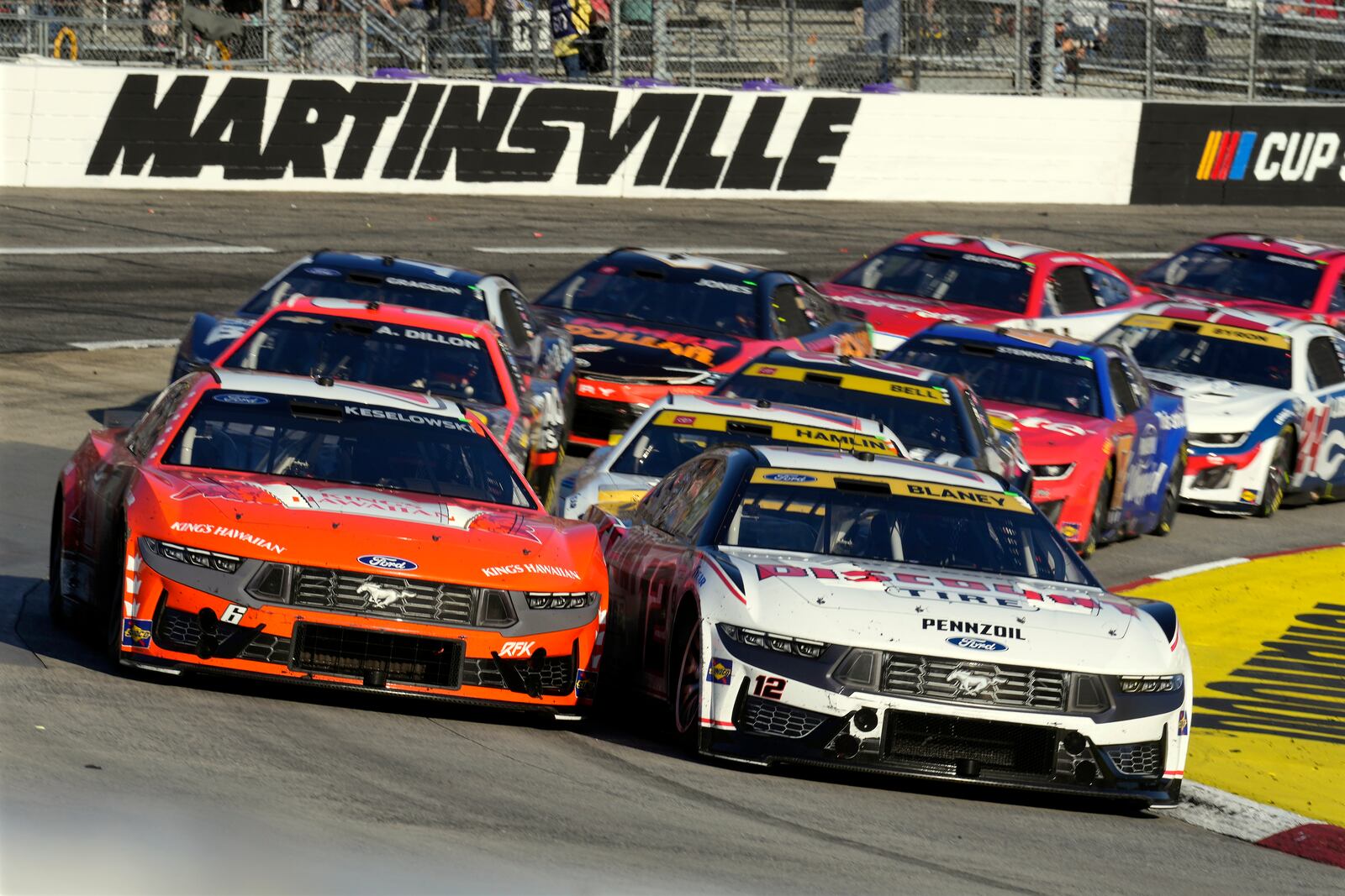 Ryan Blaney (12) leads Brad Keselowski (6) out of Turn 4 during a NASCAR Cup Series auto race at Martinsville Speedway in Martinsville, Va., Sunday, Nov. 3, 2024. (AP Photo/Chuck Burton)