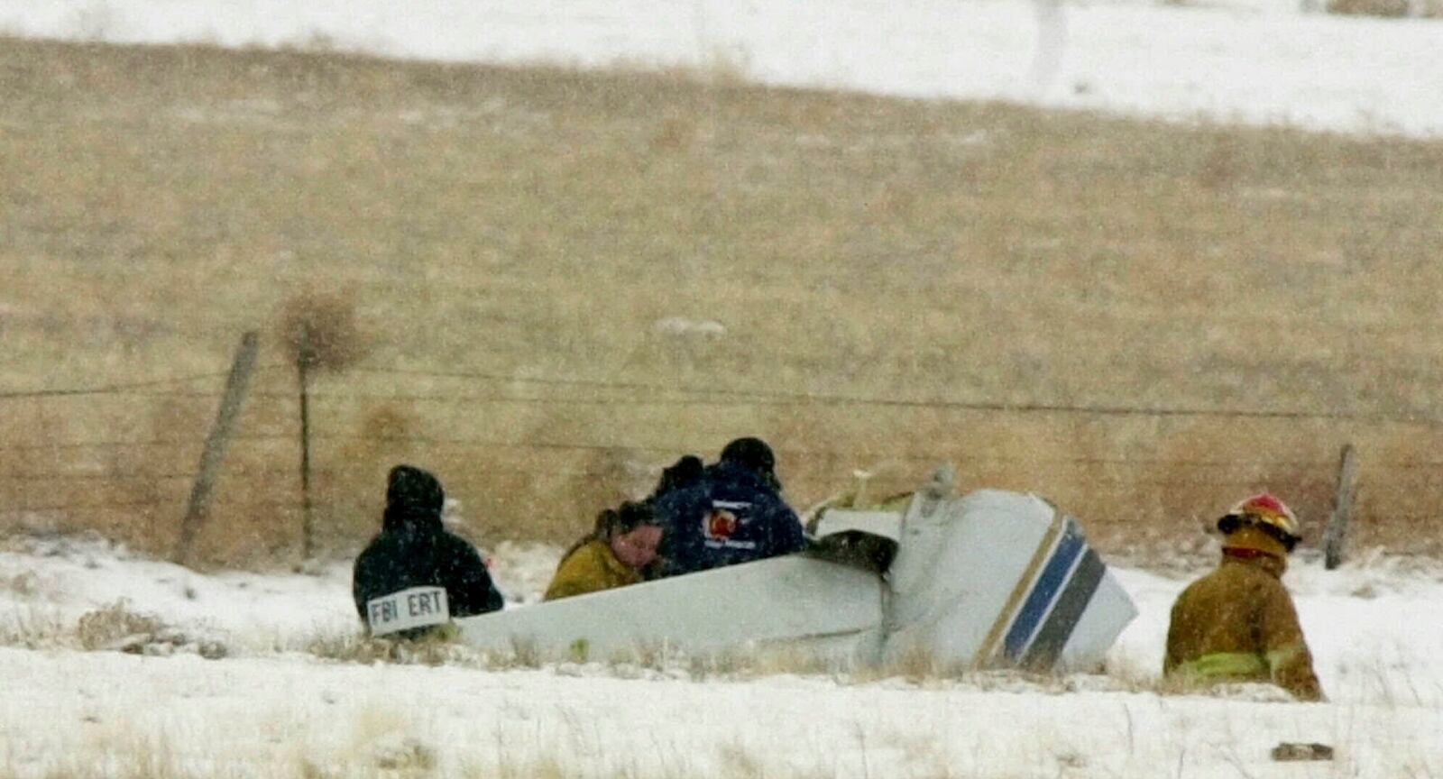 FILE - Investigators search over some of the wreckage of a small plane that crashed in a pasture outside the eastern Colorado community of Byers, Colol., Sunday, Jan. 28, 2001, that killed 10 people the day before, including two Oklahoma State basketball players and six staffers and broadcasters associated with the men's team. (AP Photo/David Zalubowski, File)