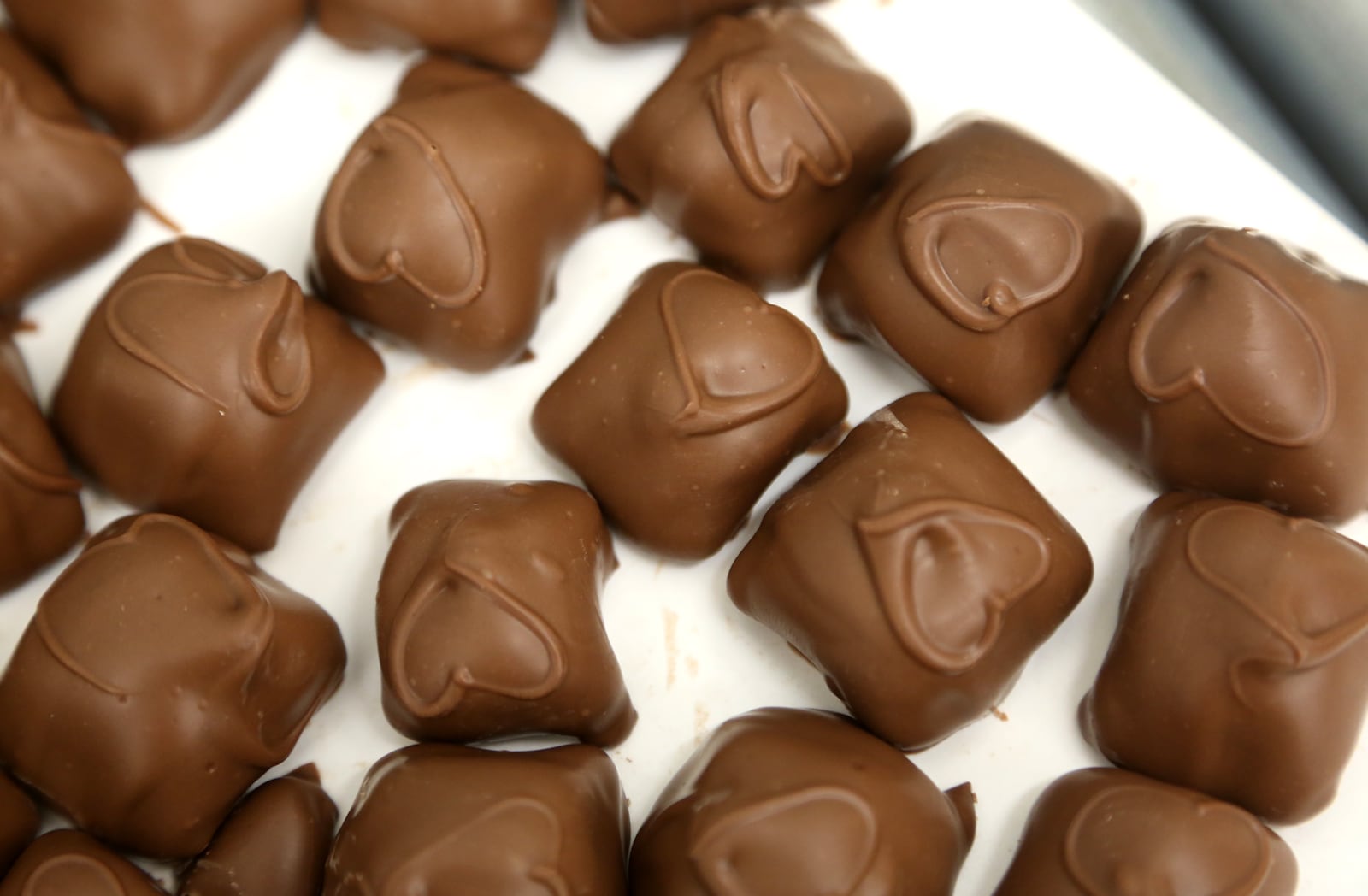 Each heart on the Esther Price peanut butter creams are hand-strung by a person in the candy factory on Wayne Avenue in Dayton. LISA POWELL / STAFF