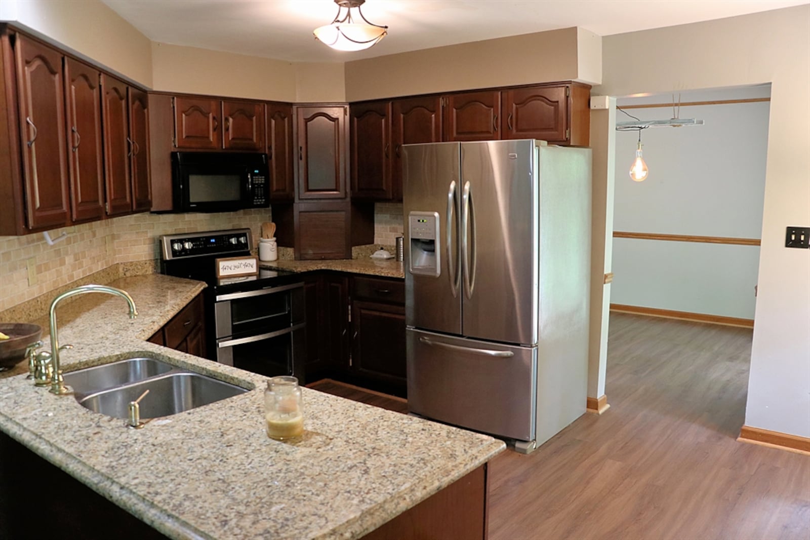 The kitchen has a granite counter and stainless-steel appliances.