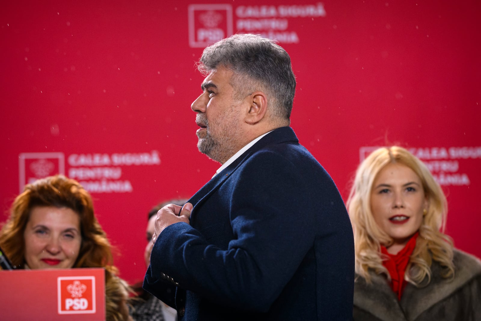 Romanian Prime Minister Marcel Ciolacu, of the Social Democratic Party or PSD, watches exit polls in the country's parliamentary elections, in Bucharest, Romania, Sunday, Dec. 1, 2024. (AP Photo/Alexandru Dobre)