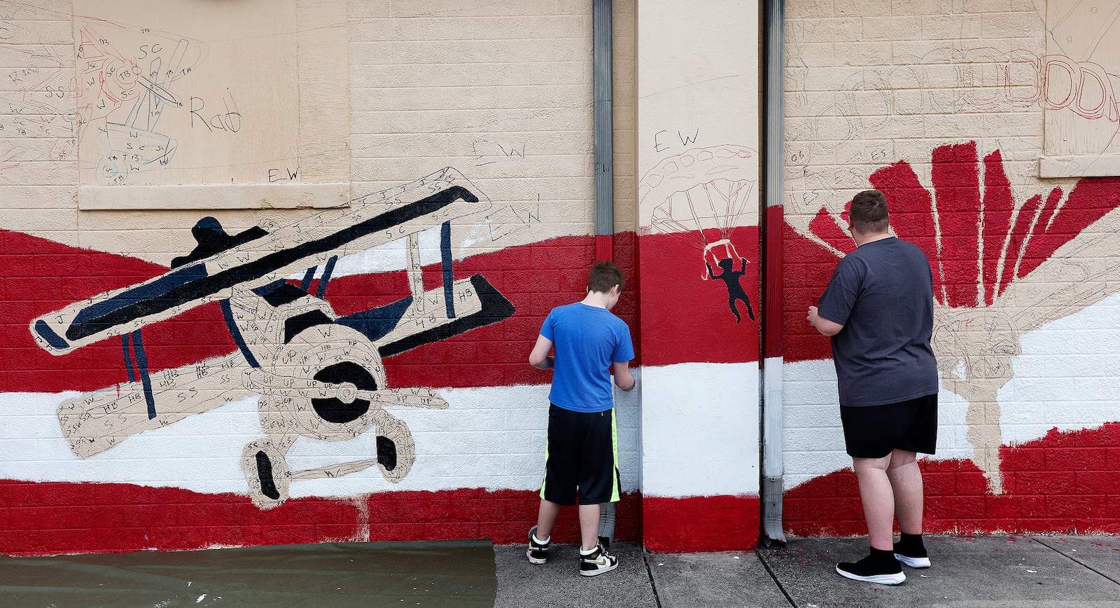 A mural going up along TNT Midwest Martial Arts Academy in Fairborn is not only a tribute to the city's military aviation history, but a positive outlet for kids involved in Greene County Juvenile Courts. MARSHALL GORBY\STAFF