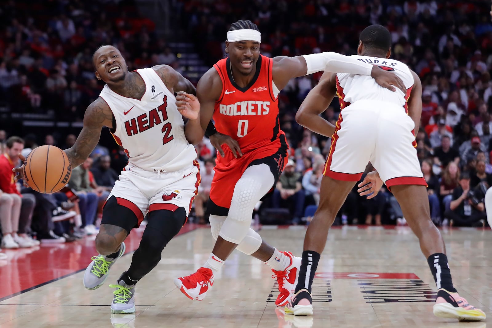 Miami Heat guard Terry Rozier III (2) drives around Houston Rockets guard Aaron Holiday (0) as Holiday is fouled on the illegal screen by guard Alec Burks, right, during the first half of an NBA basketball game Sunday, Dec. 29, 2024, in Houston. (AP Photo/Michael Wyke)