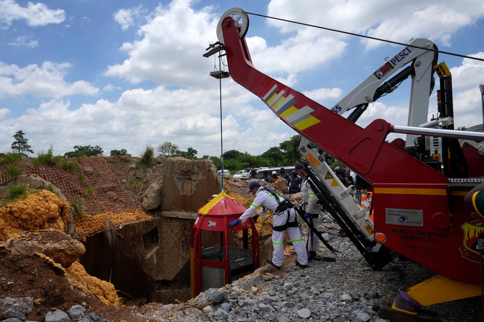 Mine rescue workers host up a cage that was used to rescue trapped miners at an abandoned gold mine, where miners were rescued from below ground, in Stilfontein, South Africa, Thursday, Jan. 16, 2025. (AP Photo/Themba Hadebe)