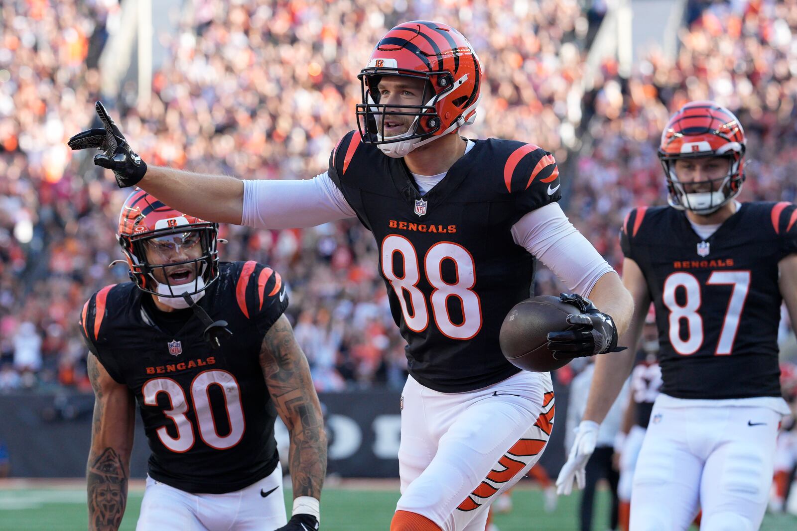 Cincinnati Bengals tight end Mike Gesicki (88) celebrates after scoring a touchdown with running back Chase Brown (30) and tight end Tanner Hudson (87) during the second half of an NFL football game against the Las Vegas Raiders in Cincinnati, Sunday, Nov. 3, 2024. (AP Photo/Jeff Dean)