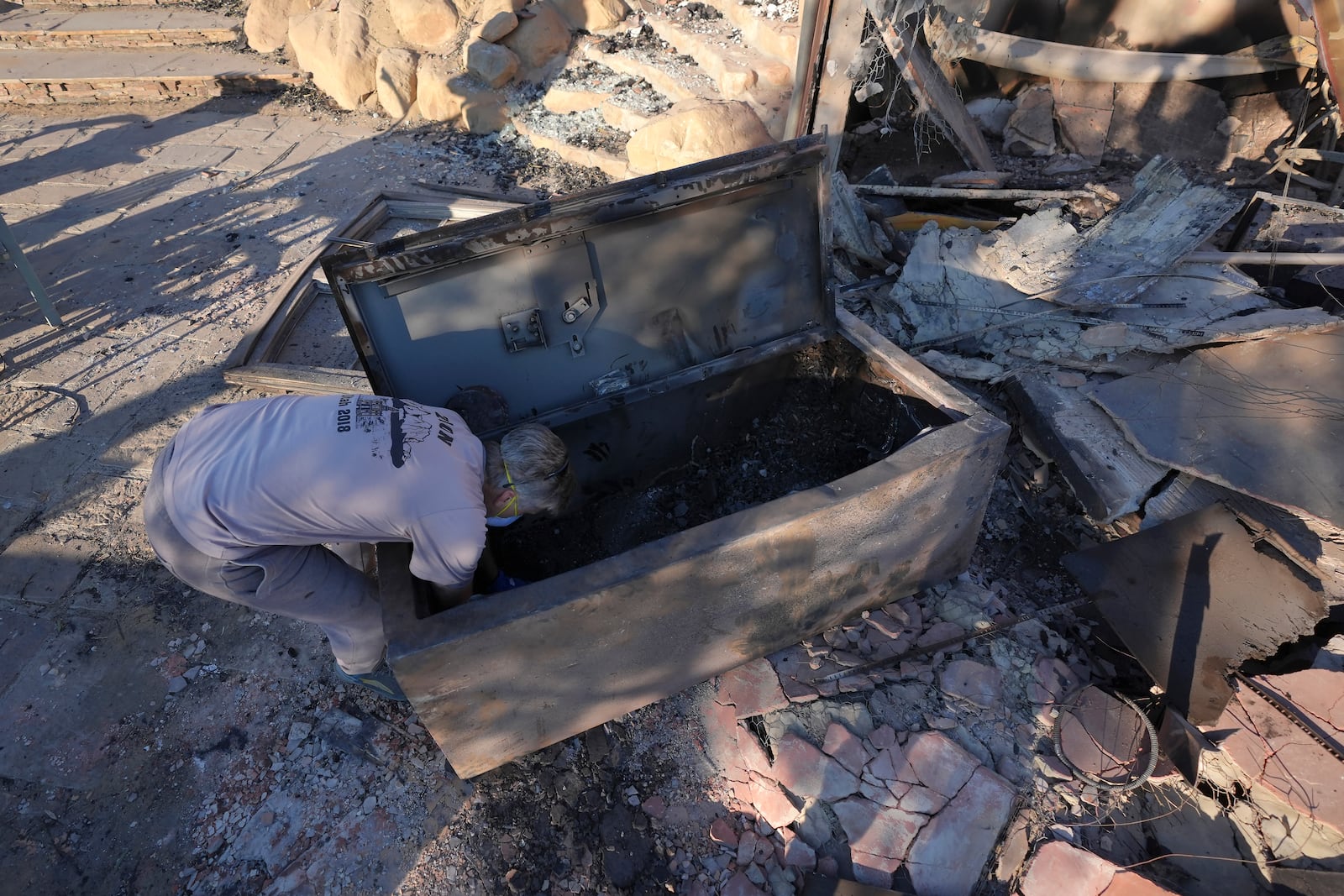 Peter Banks helps search the home of the Nardoni family that was destroyed by the Mountain Fire in Camarillo, Calif., Friday, Nov. 8, 2024. (AP Photo/Jae C. Hong)