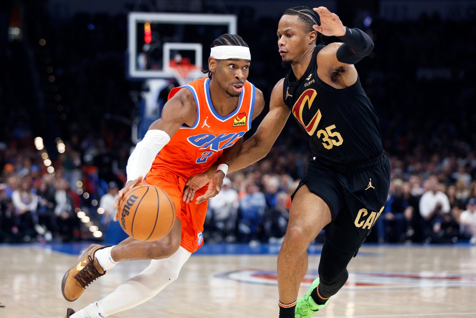 Oklahoma City Thunder guard Shai Gilgeous-Alexander (2) drives against Cleveland Cavaliers forward Isaac Okoro (35) during the first half of an NBA basketball game Thursday, Jan. 16, 2025, in Oklahoma City. (AP Photo/Nate Billings)