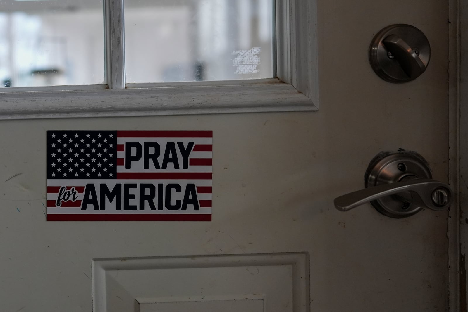 A "Pray for America" sticker is on the kitchen door of Erin and Mike Young's home in Sunbury, Ohio, Tuesday, Nov. 12, 2024, where they live with their three adopted children, Lucas, 8, Gianna, 7, and Isaac, 5. (AP Photo/Carolyn Kaster)