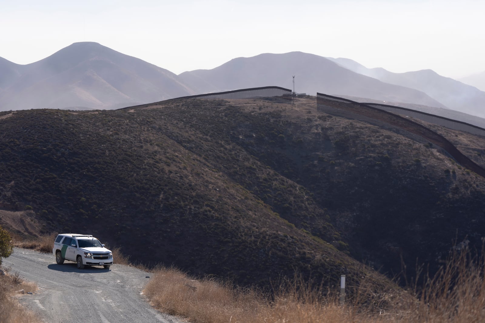 A Border Patrol vehicle sits near two border walls separating Mexico from the United States, Thursday, Jan. 23, 2025, in San Diego. (AP Photo/Gregory Bull)