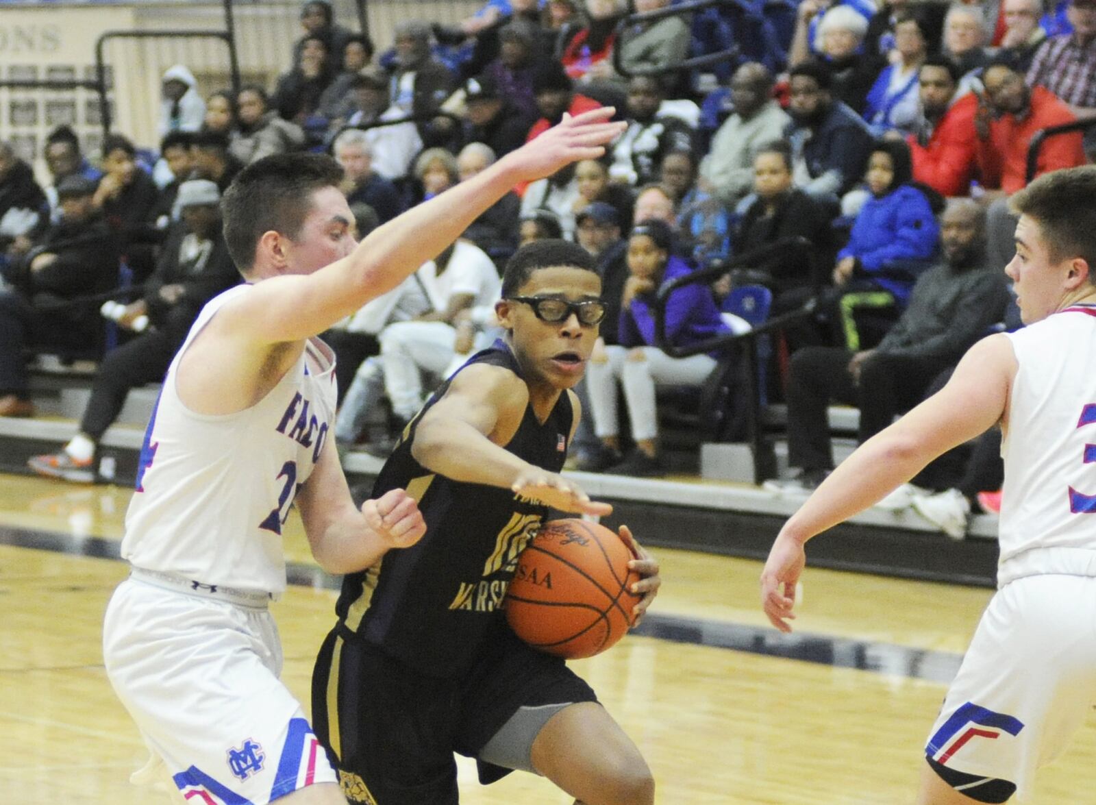 Anthony McComb of Thurgood (with ball) draws Massie defender Griffin Laake. Thurgood Marshall defeated Clinton-Massie 68-51 in a D-II boys high school basketball sectional semifinal at Trent Arena on Tuesday, Feb. 26, 2019. MARC PENDLETON / STAFF