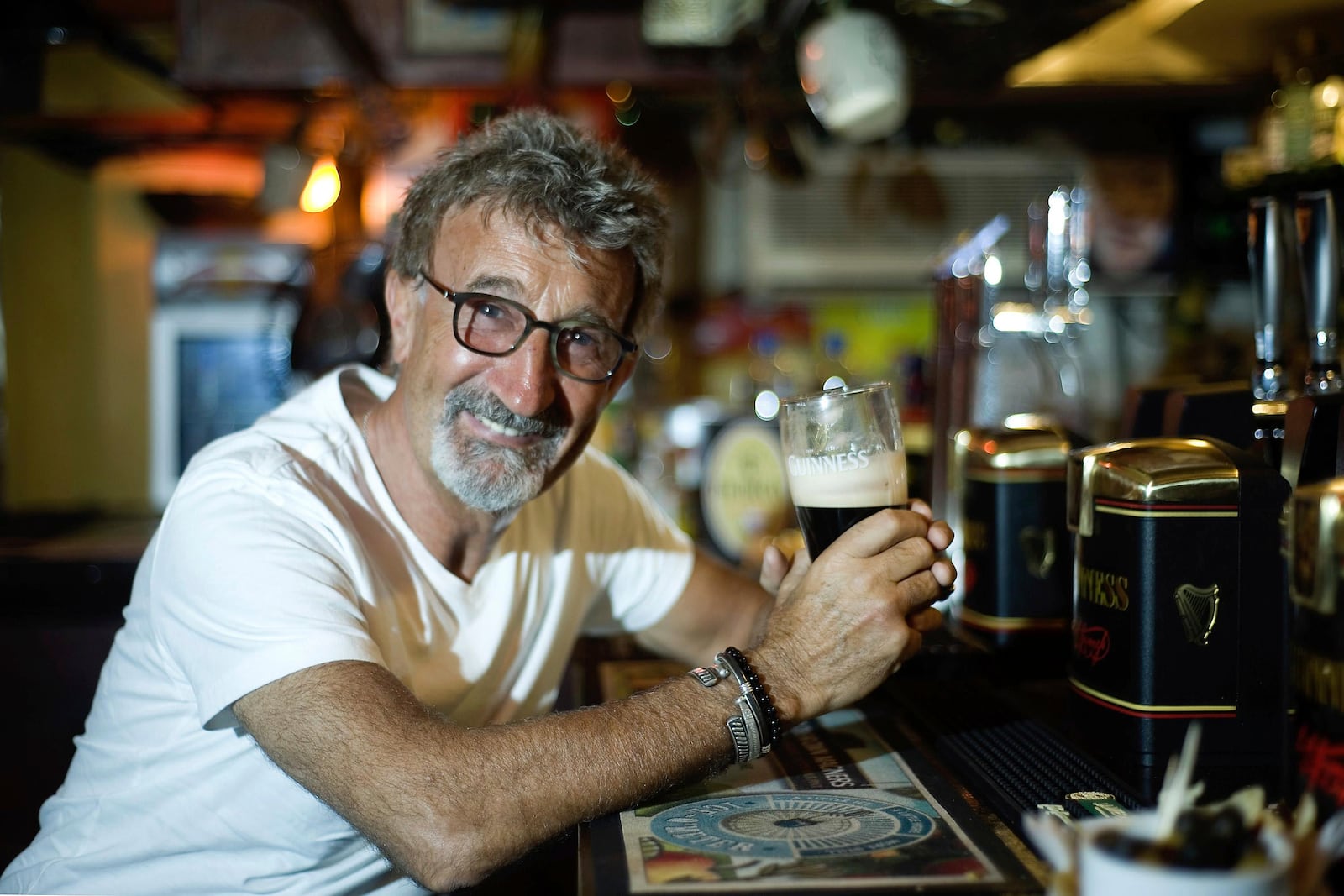 FILE - Eddie Jordan enjoys a pint of Guinness at the Toucan Bar after learning he is to be made an Officer of the British Empire, in London, March 28, 2012. (Anthony Devlin/PA via AP, File)