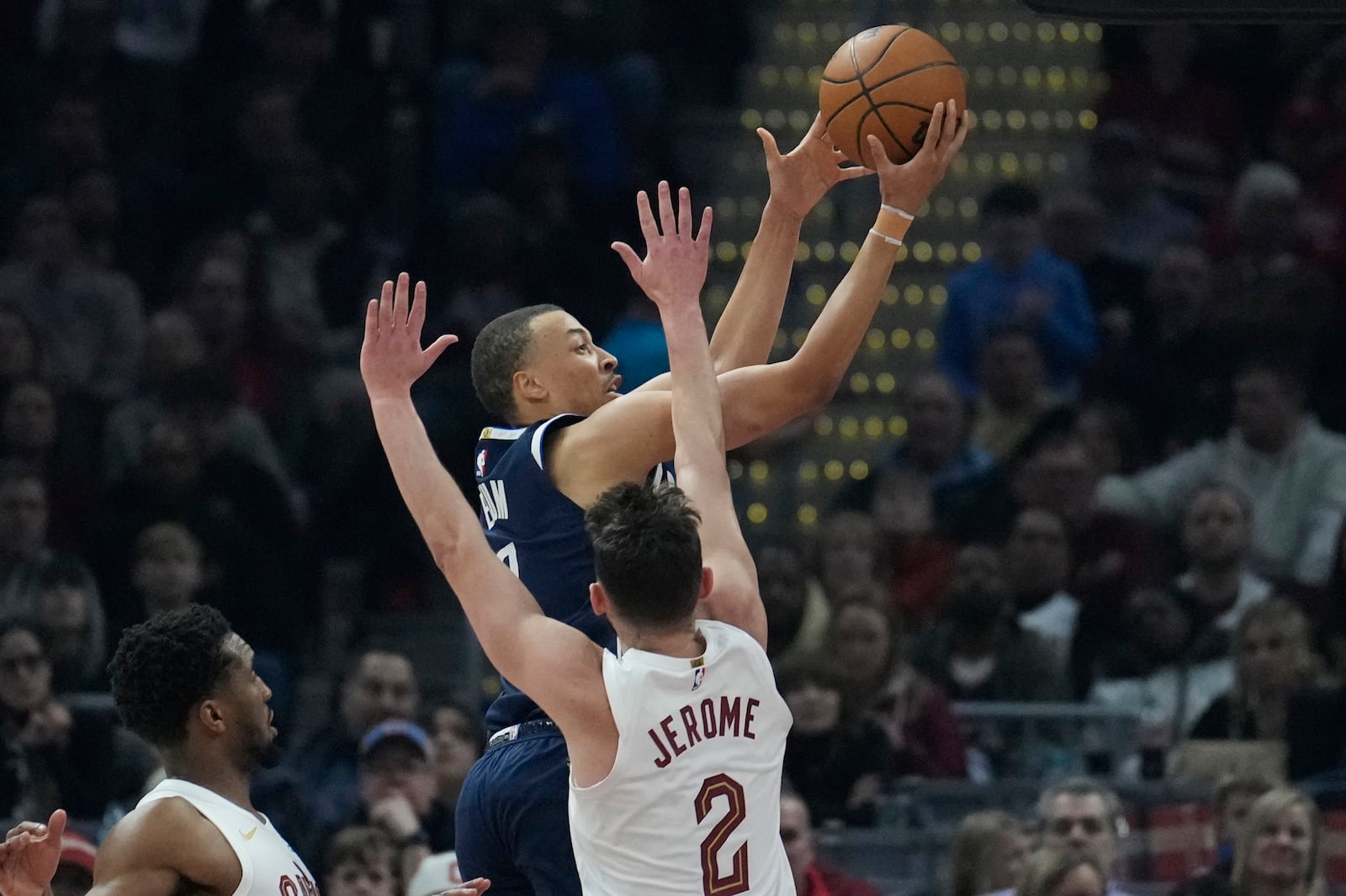 Dallas Mavericks guard Dante Exum, top, goes to the basket past Cleveland Cavaliers guard Ty Jerome (2) in the first half of an NBA basketball game, Sunday, Feb. 2, 2025, in Cleveland. (AP Photo/Sue Ogrocki)