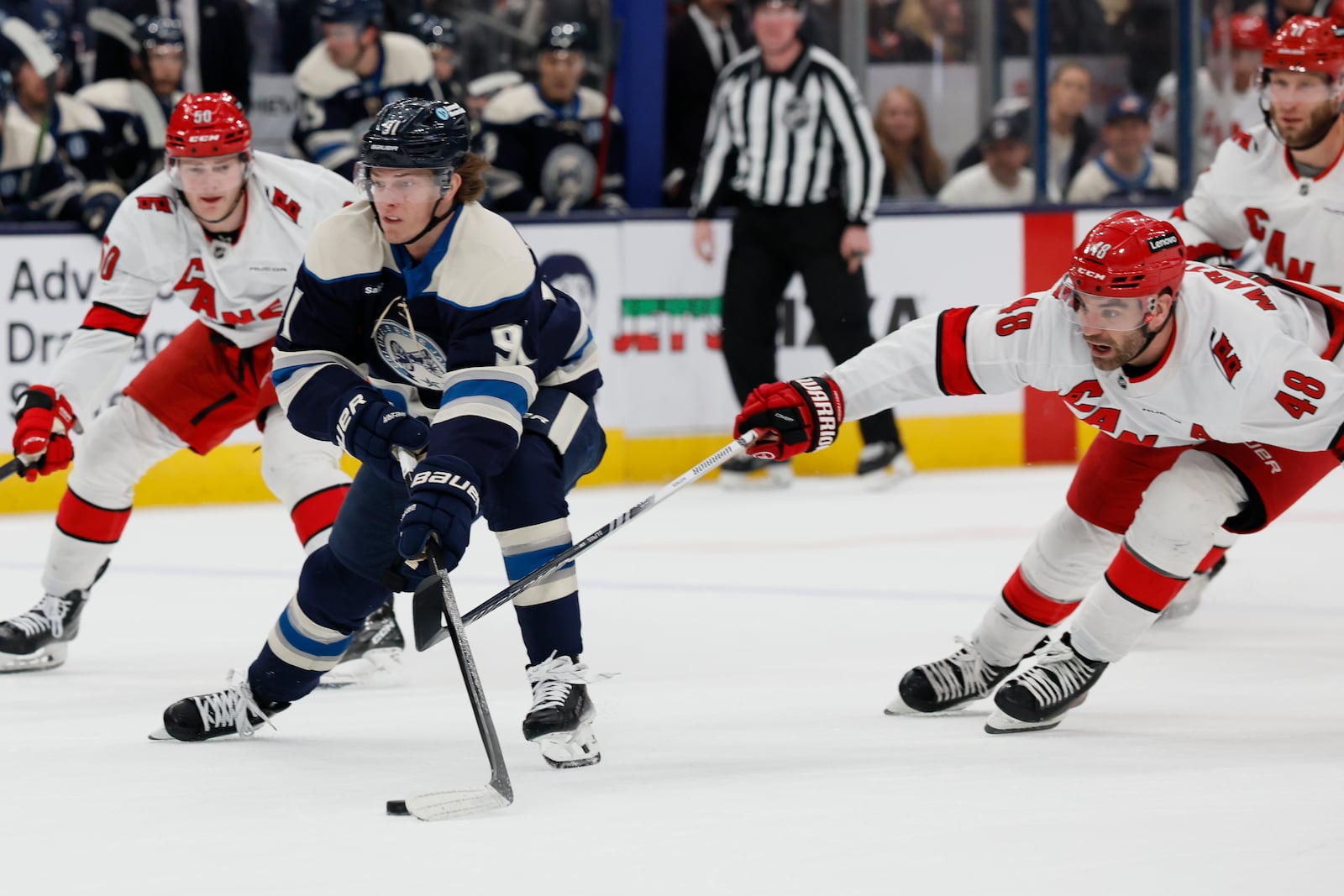 Columbus Blue Jackets' Kent Johnson, left, skates past Carolina Hurricanes' Jordan Martinook during the second period of an NHL hockey game, Tuesday, Dec. 31, 2024, in Columbus, Ohio. (AP Photo/Jay LaPrete)