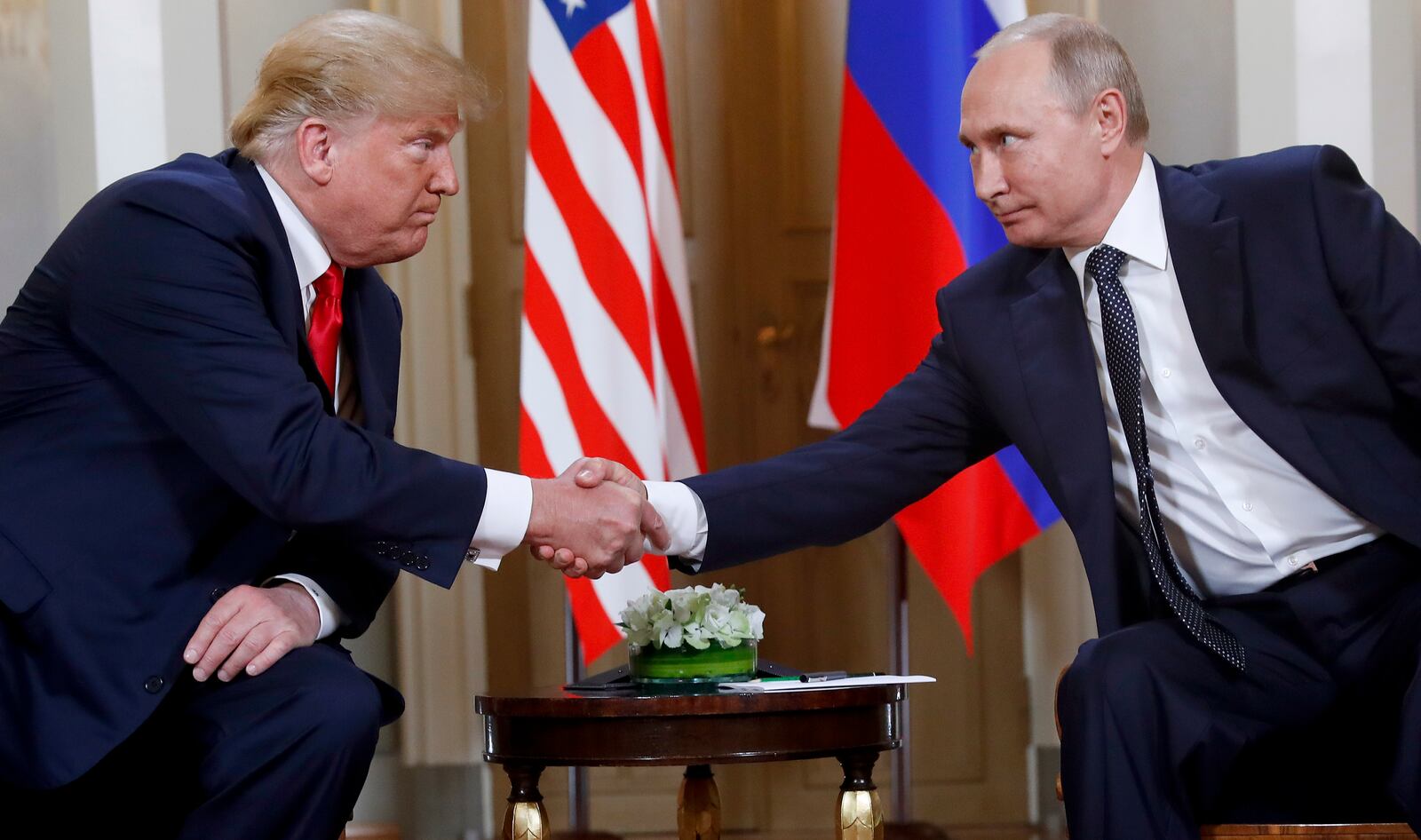 FILE - President Donald Trump, left, and Russian President Vladimir Putin shake hands at the beginning of a meeting at the Presidential Palace in Helsinki, Finland, July 16, 2018. (AP Photo/Pablo Martinez Monsivais, File)