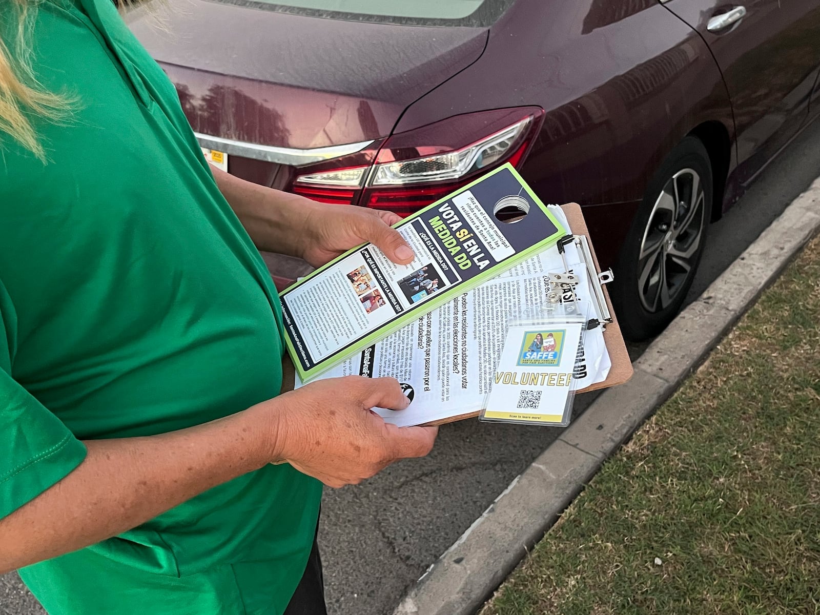 Volunteers go door-knocking on Wednesday, Oct. 23, 2024, in a Santa Ana neighborhood to encourage them to vote for Measure DD, which would allow noncitizens to vote in local elections. (AP Photo/Jaimie Ding)