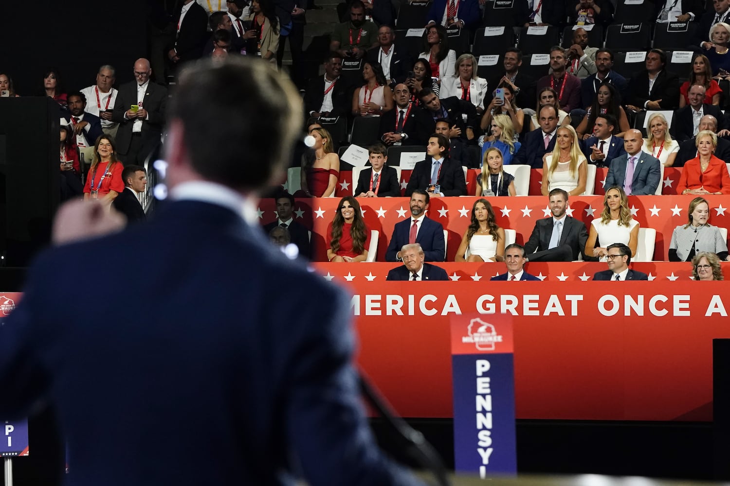 
                        Former President Donald Trump, the Republican presidential nominee, watches as Sen. JD Vance (R-Ohio), the Republican vice presidential nominee, speaks on the third night of the Republican National Convention at the Fiserv Forum in Milwaukee, on Wednesday, July 17, 2024. Front row from left: Trump, Gov.. Doug Burgum of North Dakota, House Speaker Mike Johnson (R-La.) and Beverly Vance. (Haiyun Jiang/The New York Times)
                      