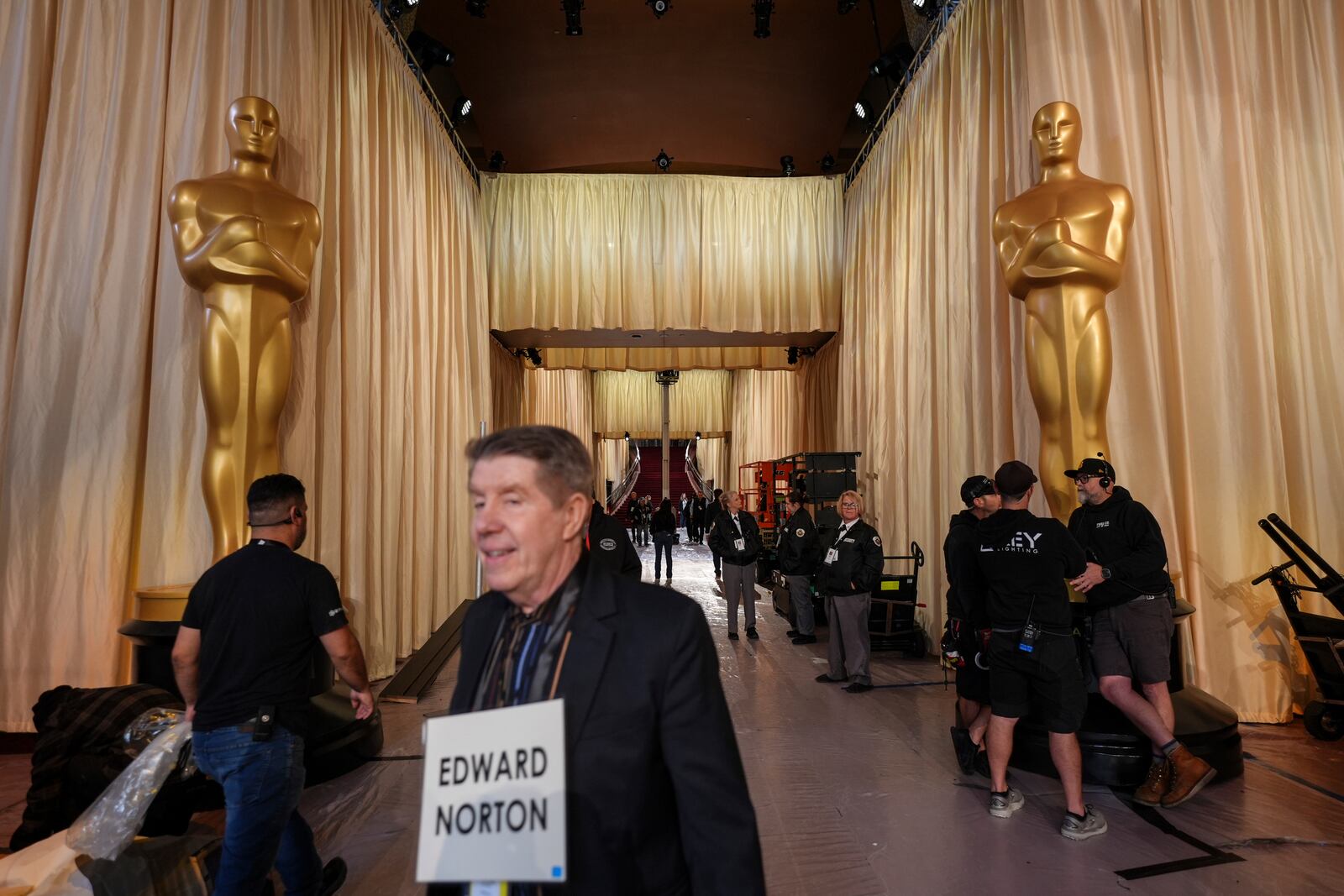 A stand-in walks past Oscar statues in the red carpet area before the 97th Academy Awards in Los Angeles, Saturday, March 1, 2025. (AP Photo/Jae C. Hong)