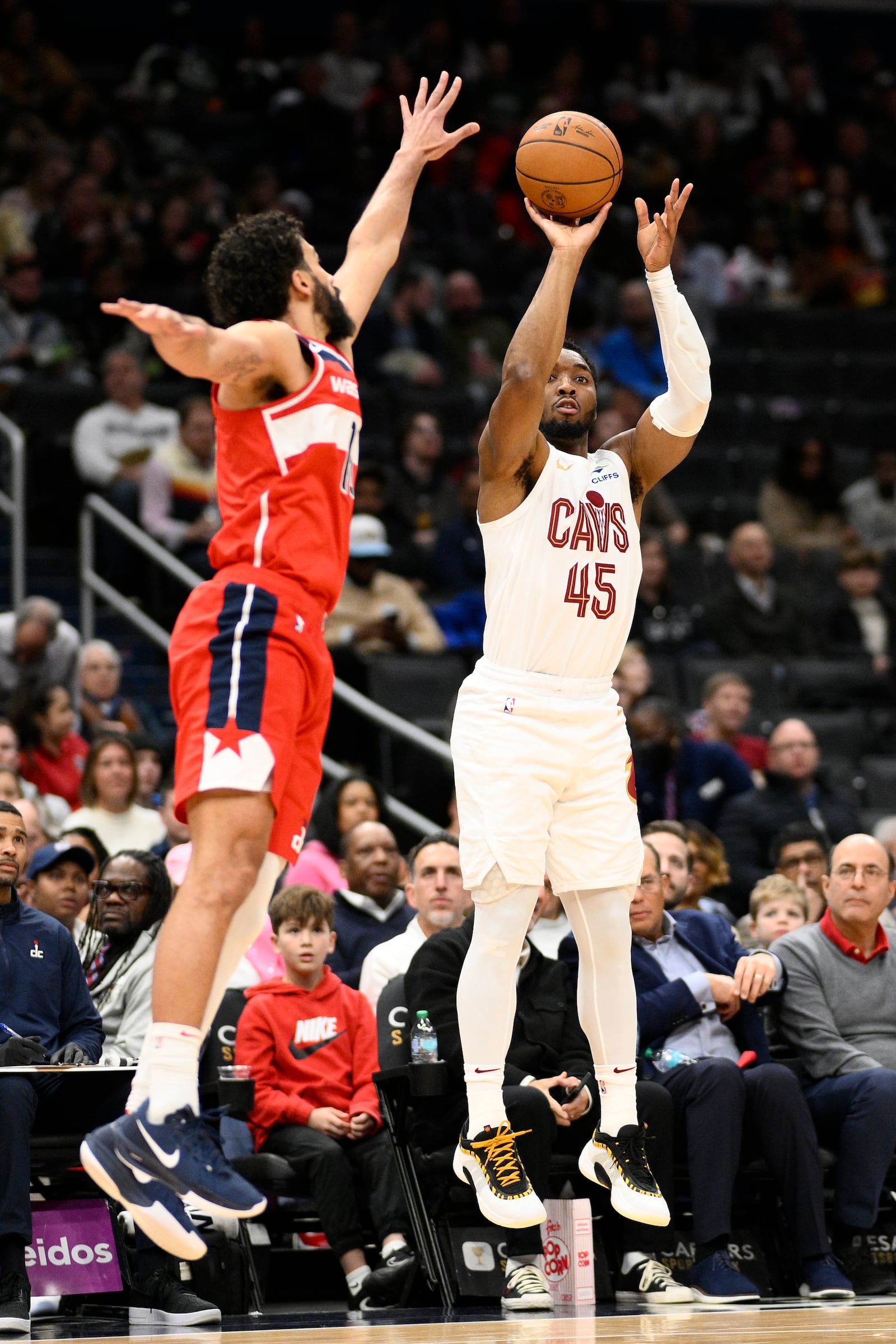 Cleveland Cavaliers guard Donovan Mitchell (45) goes up to shoot against Washington Wizards forward Anthony Gill, left, during the first half of an NBA basketball game, Friday, Feb. 7, 2025, in Washington. (AP Photo/Nick Wass)