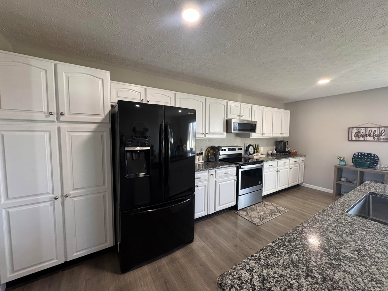 The updated kitchen has all new flooring and cabinets and granite countertops