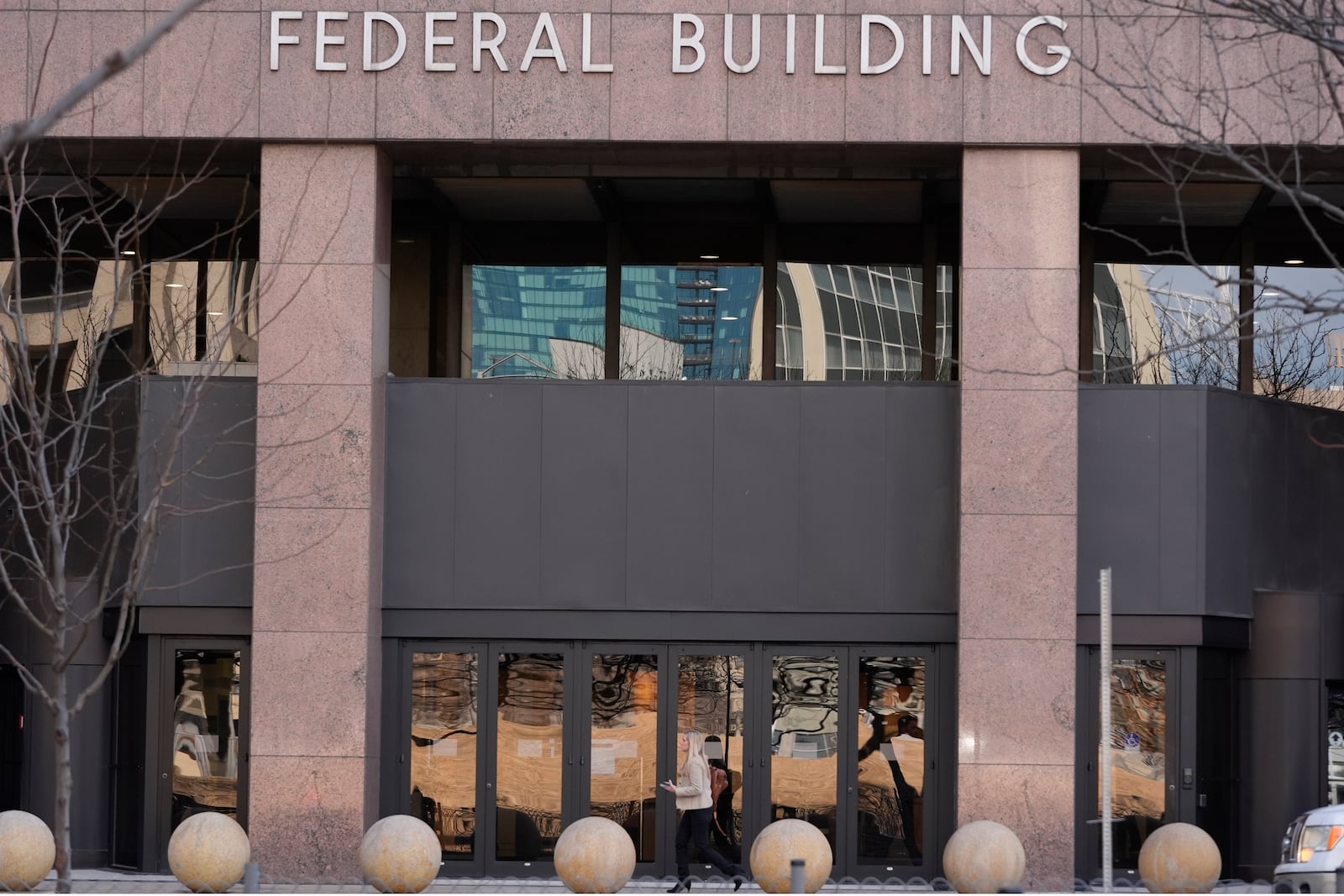 A woman walks past the Earle Cabell Federal Building in downtown Dallas, Monday, Feb. 24, 2025. (AP Photo/LM Otero)