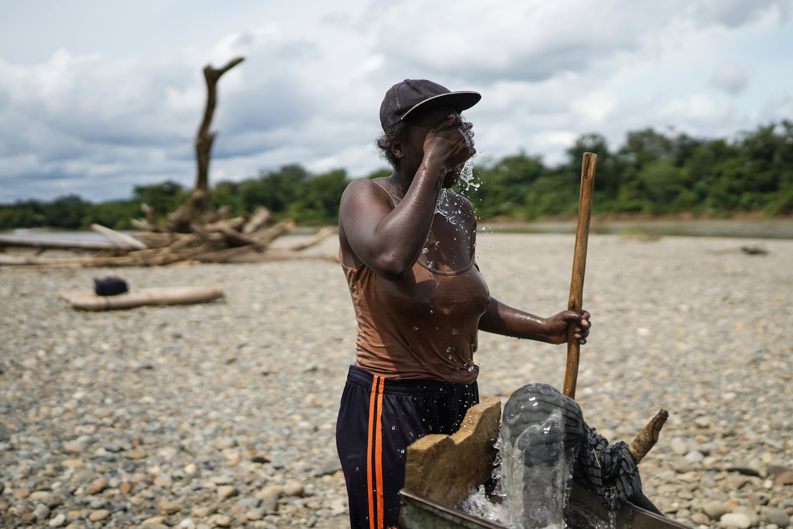 A small-scale miner cools off while looking for gold at the Atrato River, in Dona Josefa, Colombia, Thursday, Sept. 26, 2024. (AP Photo/Ivan Valencia)