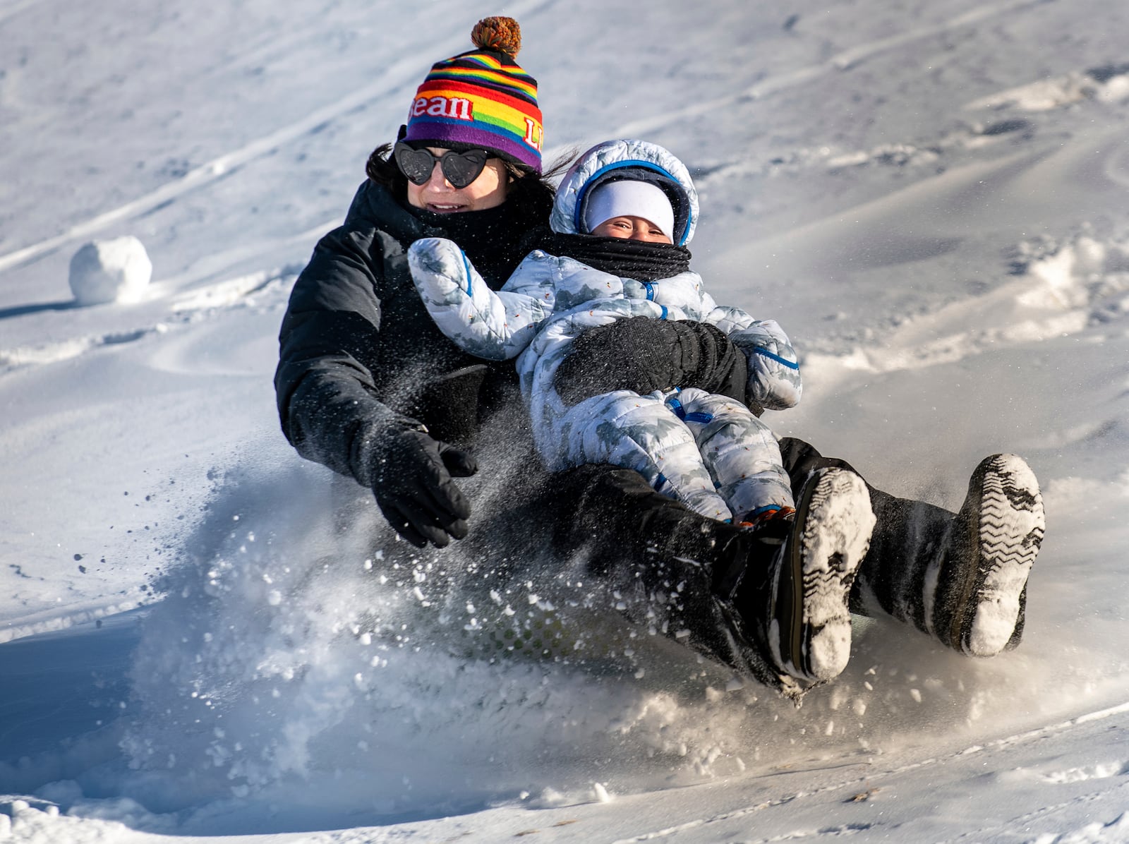 Hailee Morin holds her child, Guide Monday morning as they zip down the hill behind Sherwood Heights Elementary School Auburn, Maine, Monday, Jan. 20, 2025, with their family and friends. (Russ Dillingham/Sun Journal via AP)