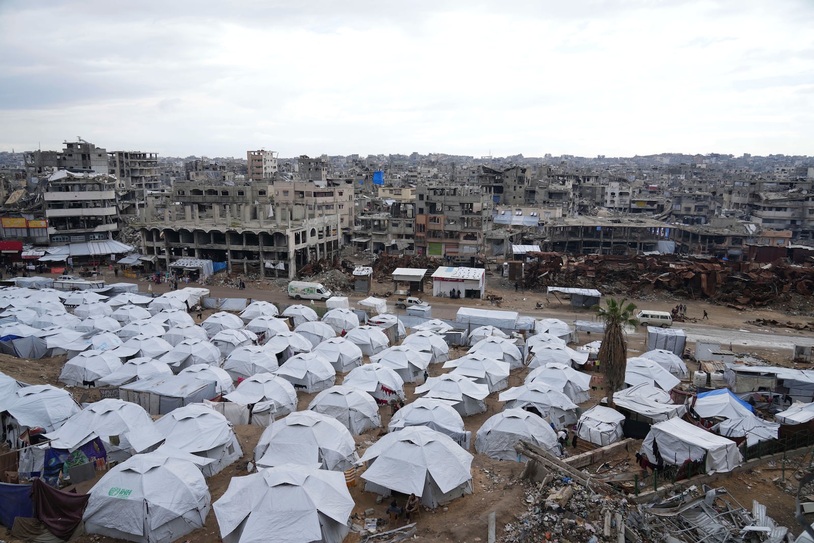 A sprawling tent camp for displaced Palestinians sits adjacent to destroyed homes and buildings in Gaza City, Gaza Strip, Saturday, March 1, 2025 during the Muslim holy month of Ramadan. (AP Photo/Abdel Kareem Hana)