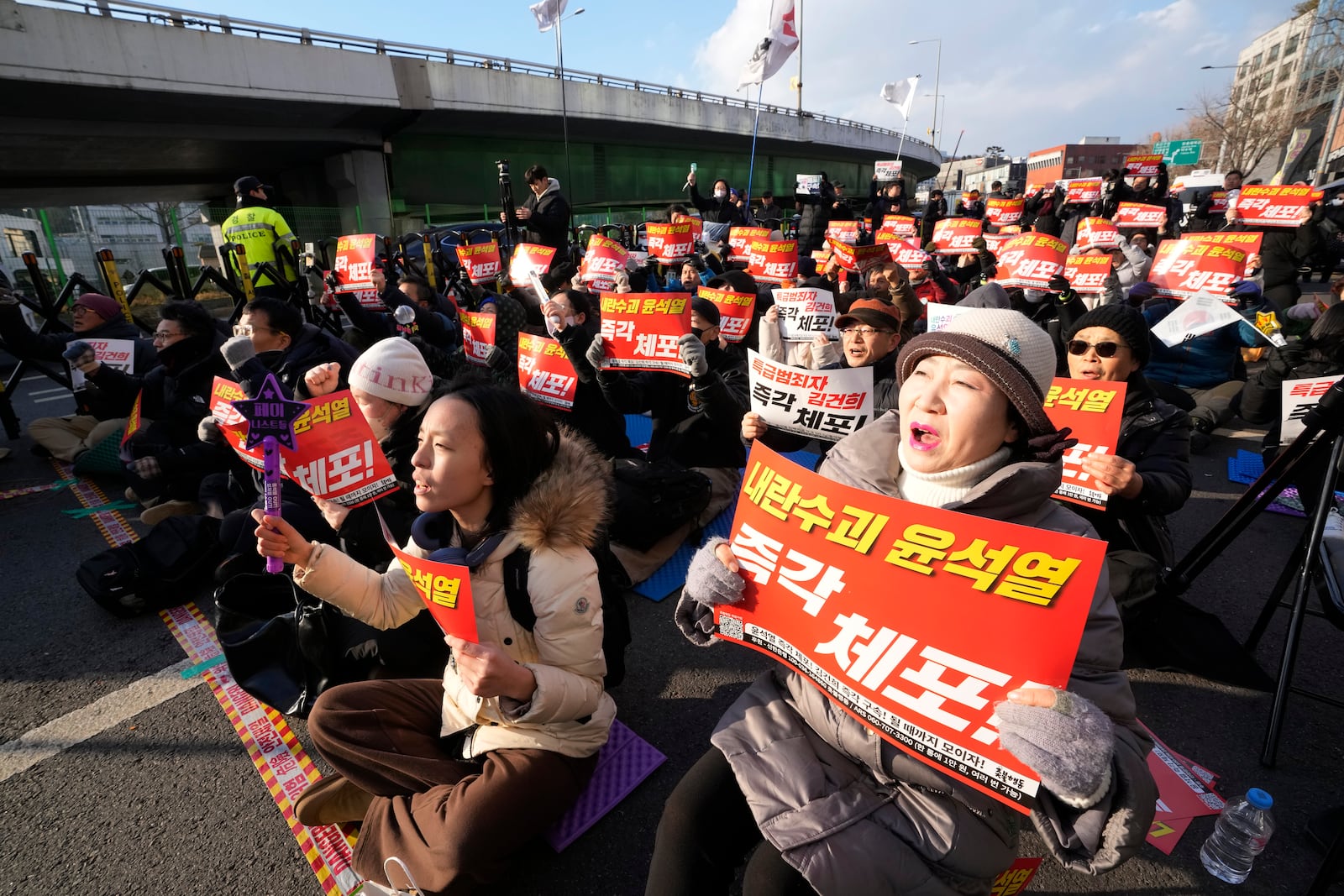 Protesters attend a rally demanding the arrest of impeached South Korean President Yoon Suk Yeol near the presidential residence in Seoul, South Korea, Wednesday, Jan. 8, 2025. The letters read "Arrest Yoon Suk Yeol." (AP Photo/Ahn Young-joon)