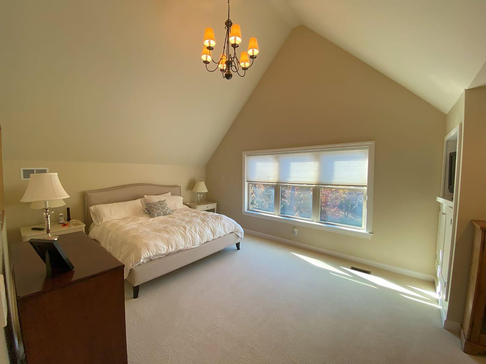 The primary suite takes over the entire second level and has neutral carpeting and a vaulted ceiling and ensuite bathroom.