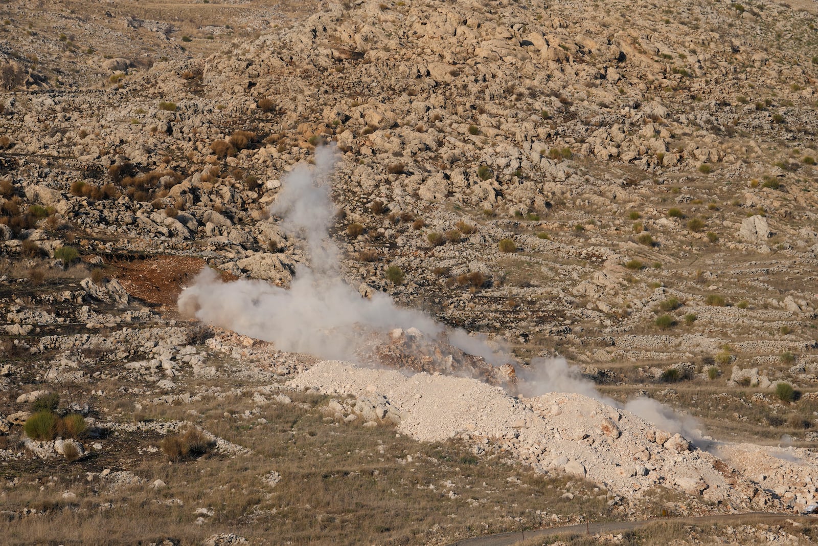 Smoke rises from a controlled explosion inside the buffer zone near the so-called Alpha Line that separates the Israeli-controlled Golan Heights from Syria, in Majdal Shams, Tuesday, Dec. 17, 2024. (AP Photo/Matias Delacroix)