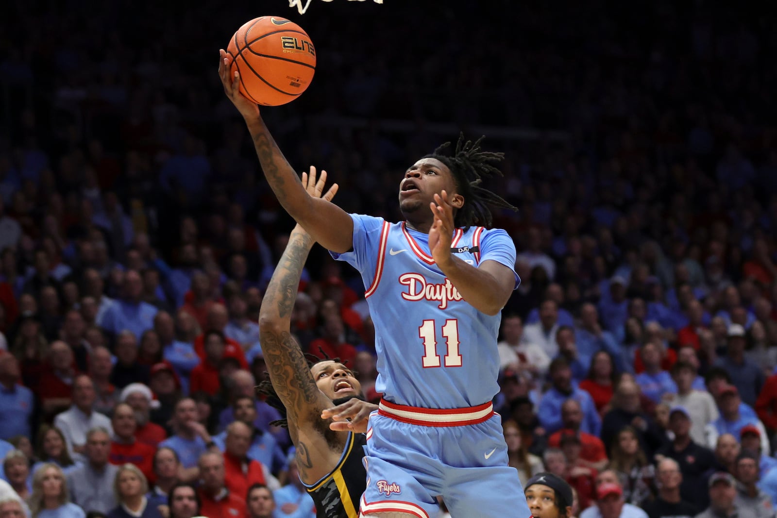 Dayton guard Malachi Smith, right, shoots in front of Marquette forward David Joplin during the second half of an NCAA college basketball game in Dayton, Ohio, Saturday, Dec. 14, 2024. Dayton won 71-63. (AP Photo/Paul Vernon)