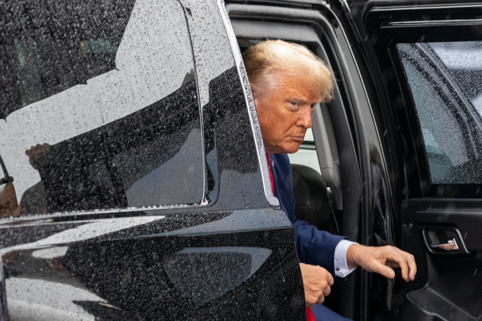 FILE - Former President Donald Trump exits his vehicle to walk over to speak with reporters before he boards his plane at Ronald Reagan Washington National Airport, in Arlington, Va., Aug. 3, 2023. (AP Photo/Alex Brandon, File)