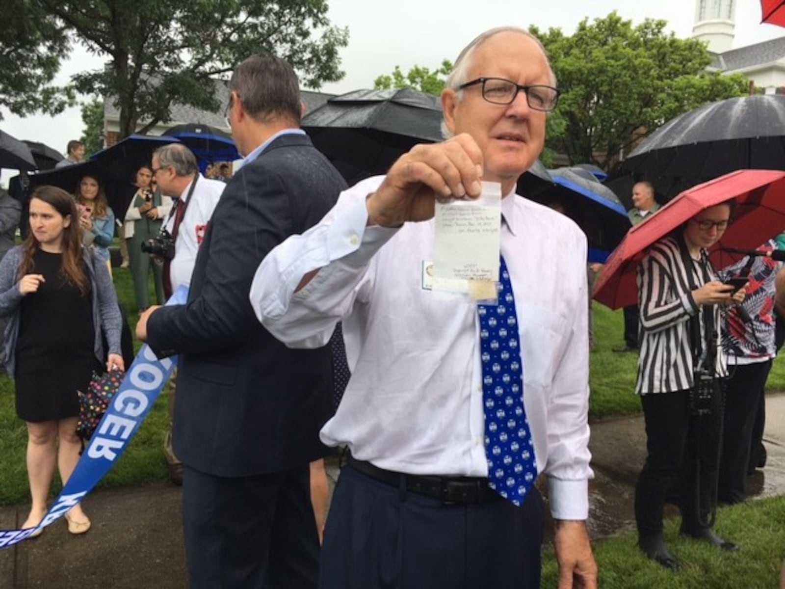 Centerville Mayor Brooks Compton holds up a piece of cloth from the first Wright Brothers Flyer, which was delivered with the first commercial drone delivery from Kroger Wednesday June 9, 2021. THOMAS GNAU/STAFF